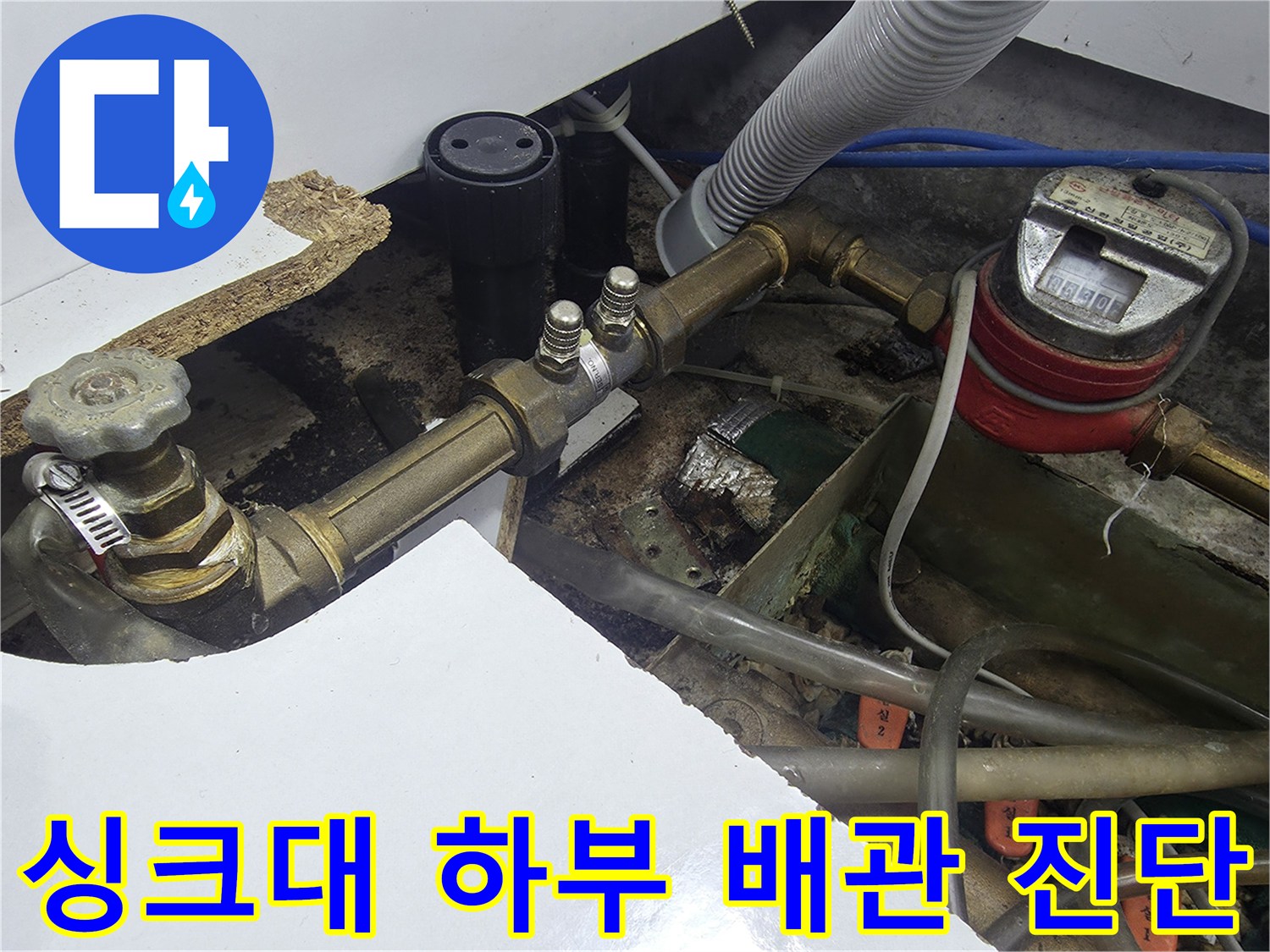 싱크대 아래 복잡하게 연결된 수도 계량기와 금속 급수 라인 점검