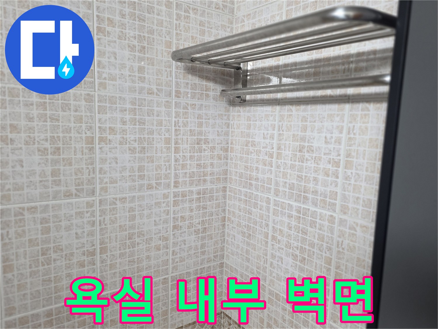 금속재질 수건걸이가 달린 타일 벽면 모습