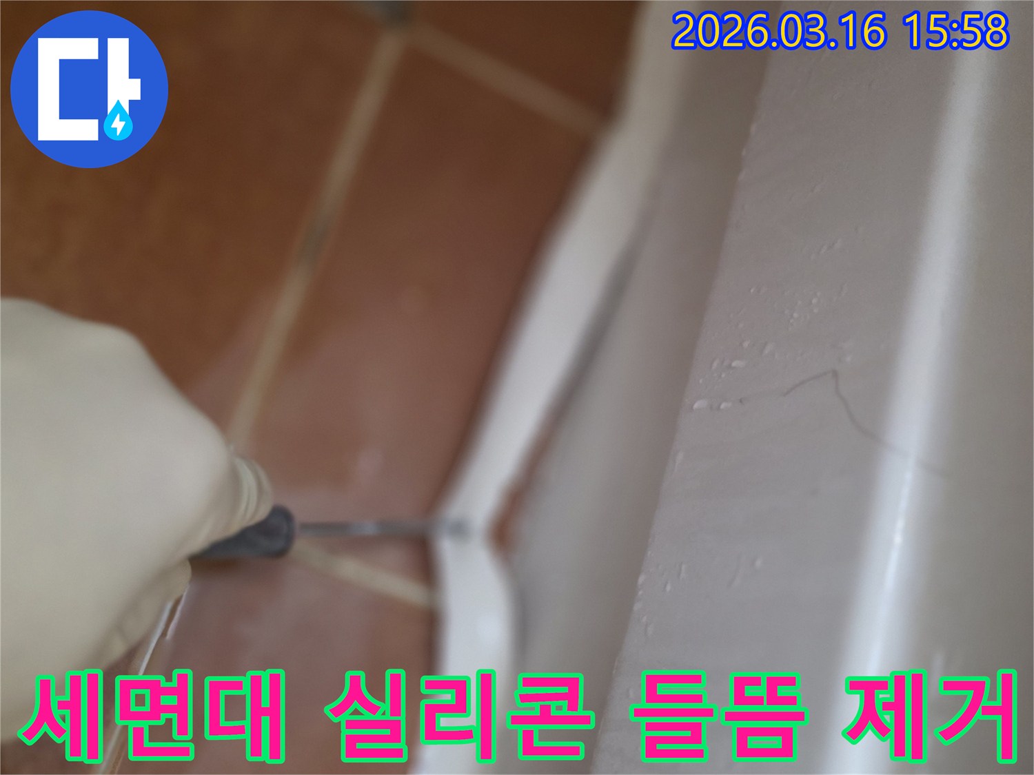 빌라 세면대 하단의-오래되고 들뜬 실리콘을-전문가가 제거하는 작업 현장