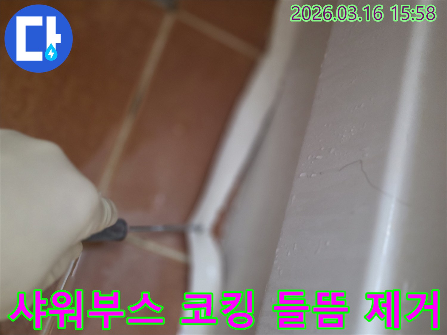 아파트 샤워부스 코킹의-오래되고 들뜬 부분을-전문가가 제거하는 작업 현장