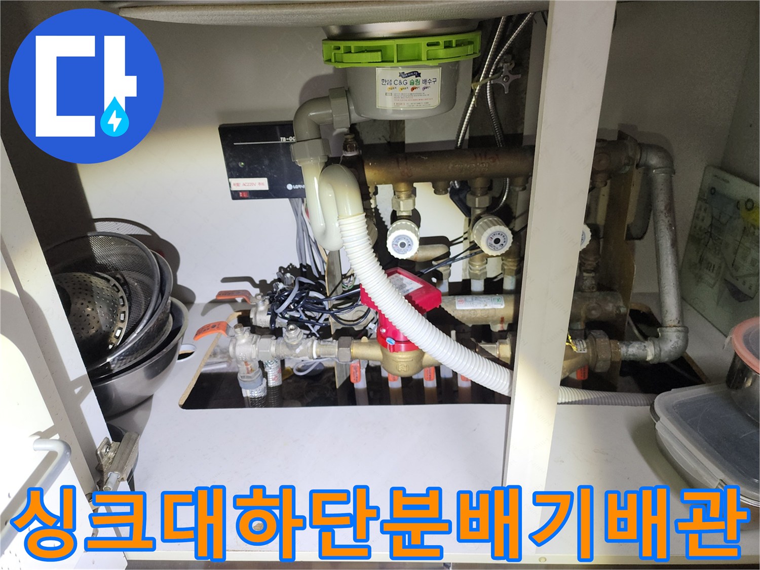 싱크대-하단에-복잡하게-얽혀있는-난방-분배기와-연결-배관들