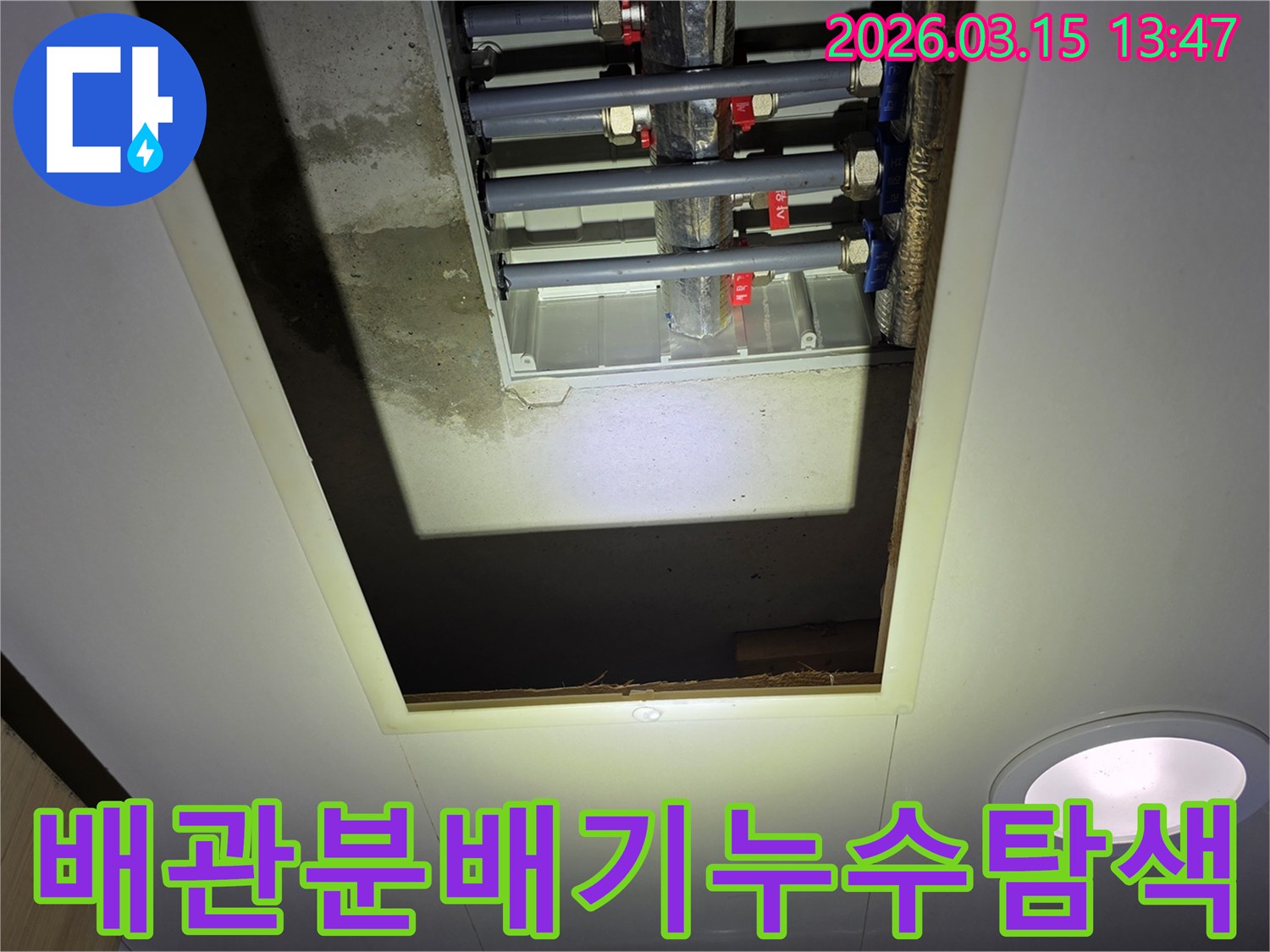 천장 개구부 안-다수의 배관이 연결된-분배기 주변에서-누수 지점을 찾는 모습
