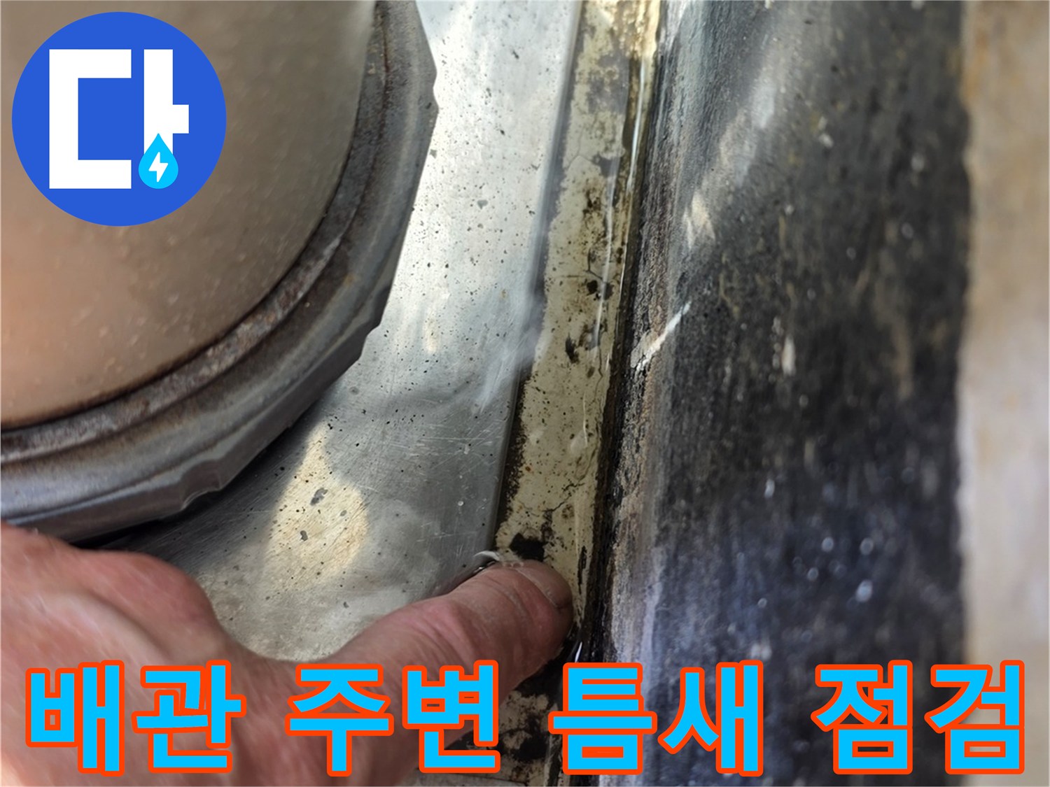 배관과 벽 사이 벌어진 틈을 손으로 확인하는 작업자