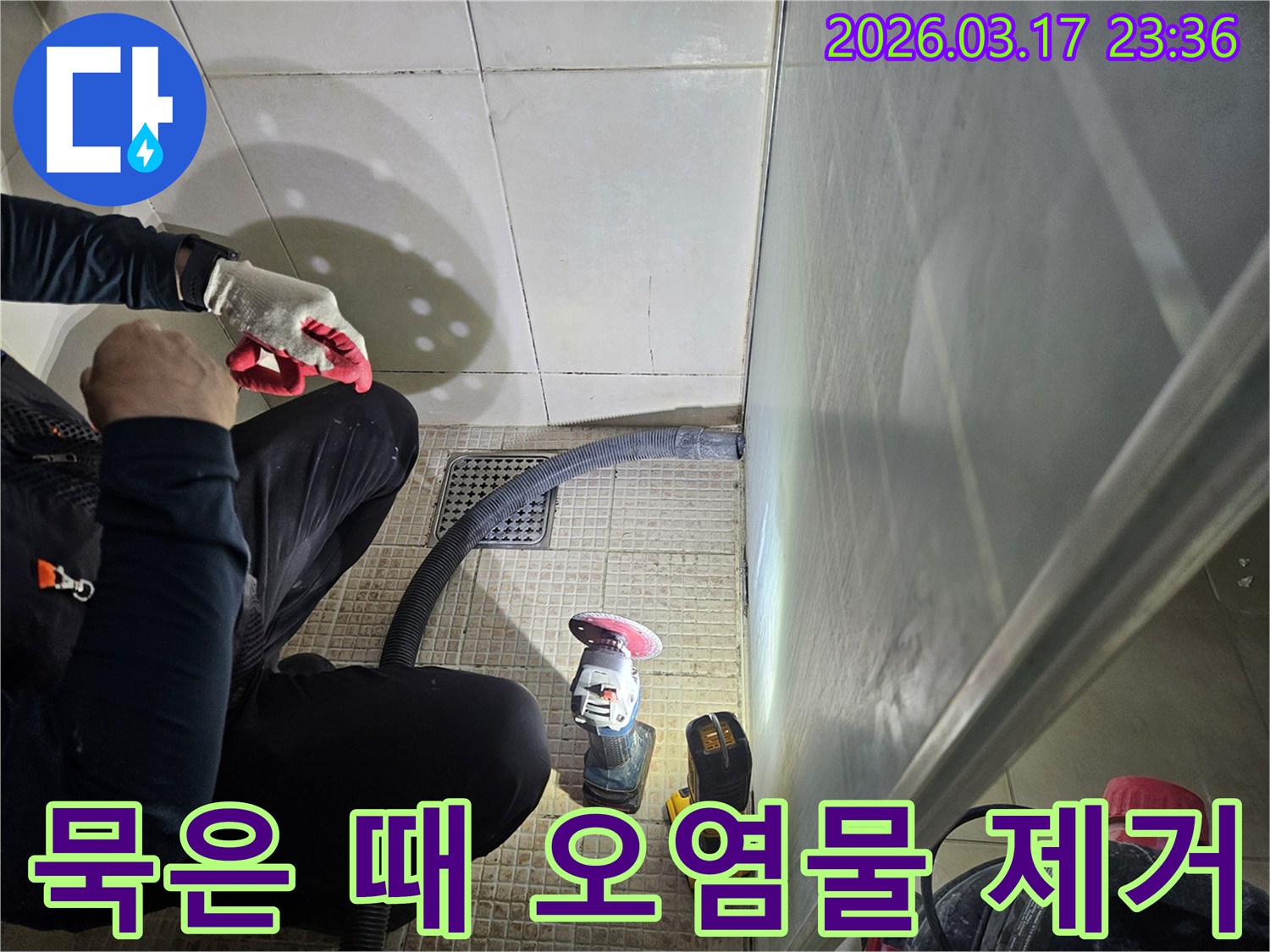 누수 전문가가-욕실 바닥의-묵은 때와 오염물을-깨끗하게 제거하고 있습니다
