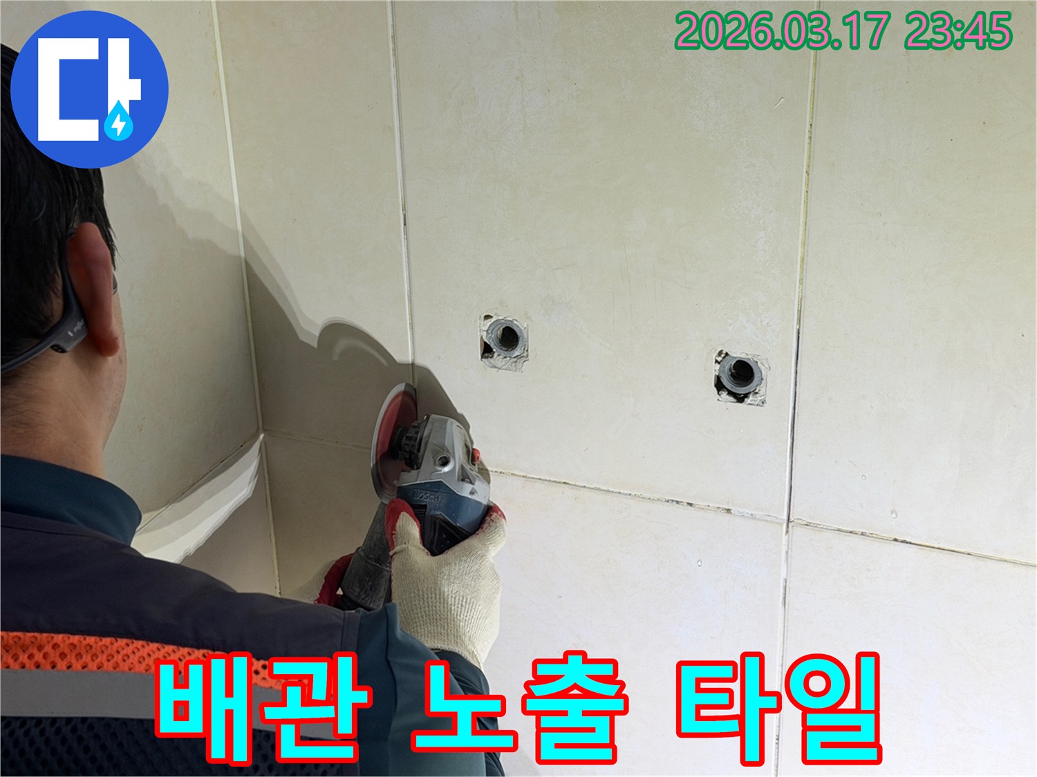 누수된 배관을-노출시키기 위해-전문가가-타일 벽면을-그라인더로-조심스럽게-커팅하고-있습니다