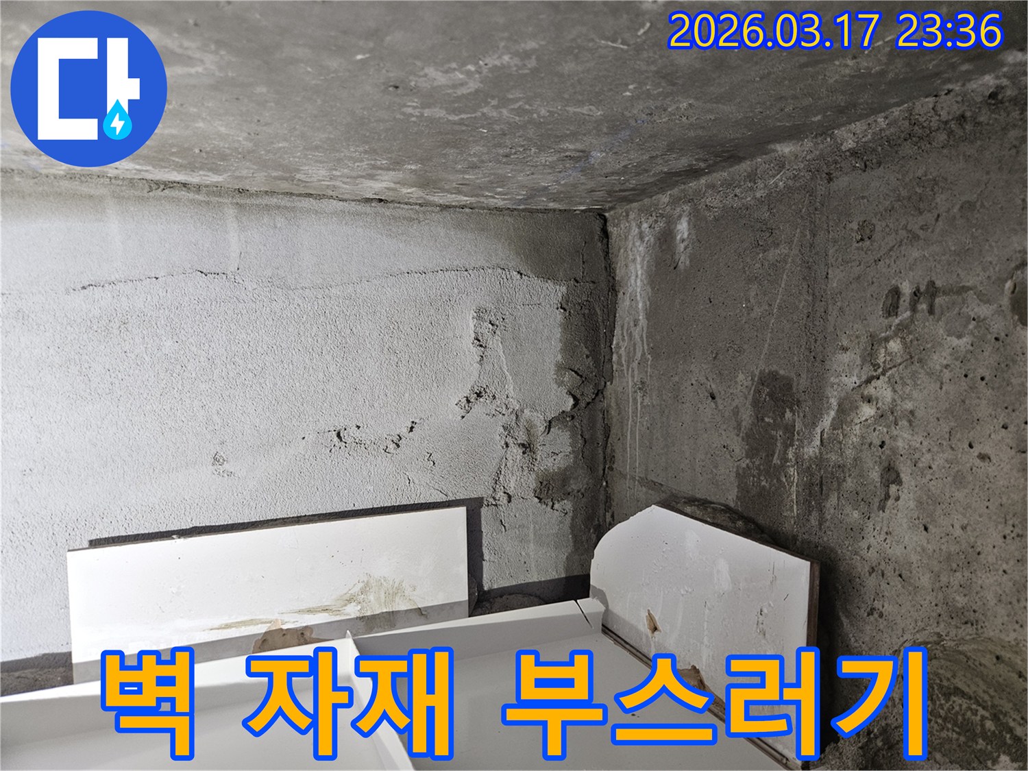 누수로 인해 벽면 자재가 부스러져 바닥에 떨어진 모습-재료 손상이 심각한 상태입니다.