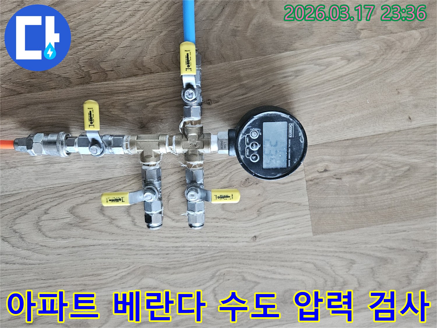 아파트 베란다 수도 배관의 누수 여부를 확인하기 위해-정밀한 압력 테스트 장비를 연결하여-수치를 측정하고 있습니다.