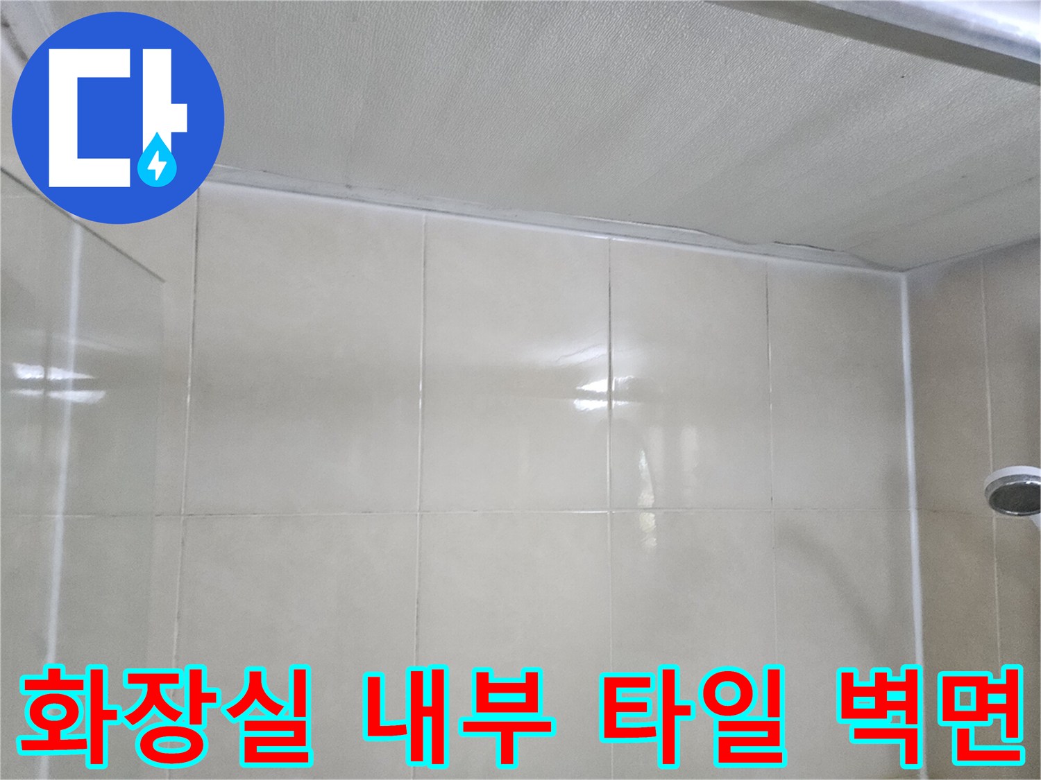 정돈된 상태의 화장실 내부 타일벽과 천장 경계부