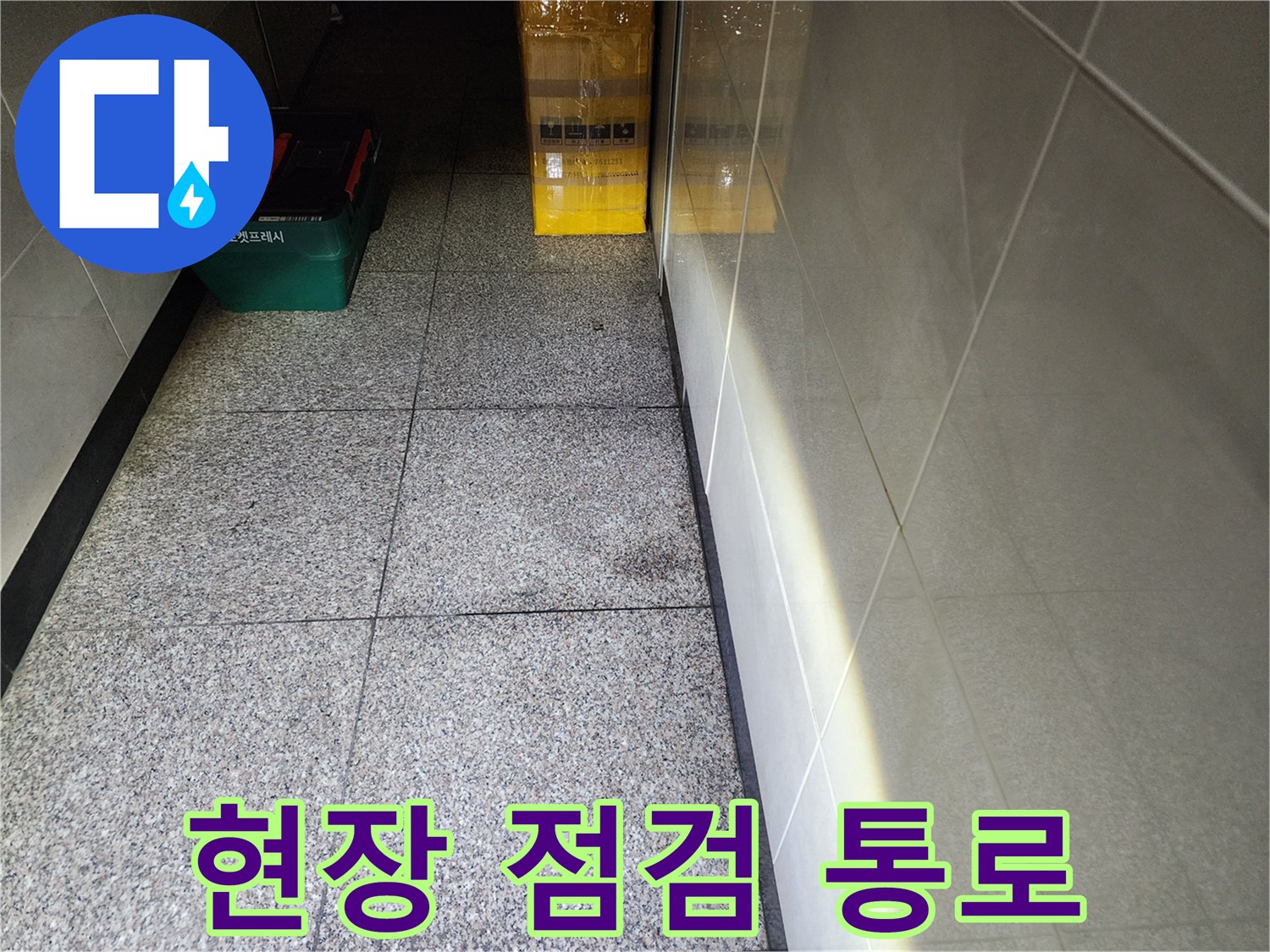 건물 복도 바닥에 놓인 작업용 공구 상자 모습