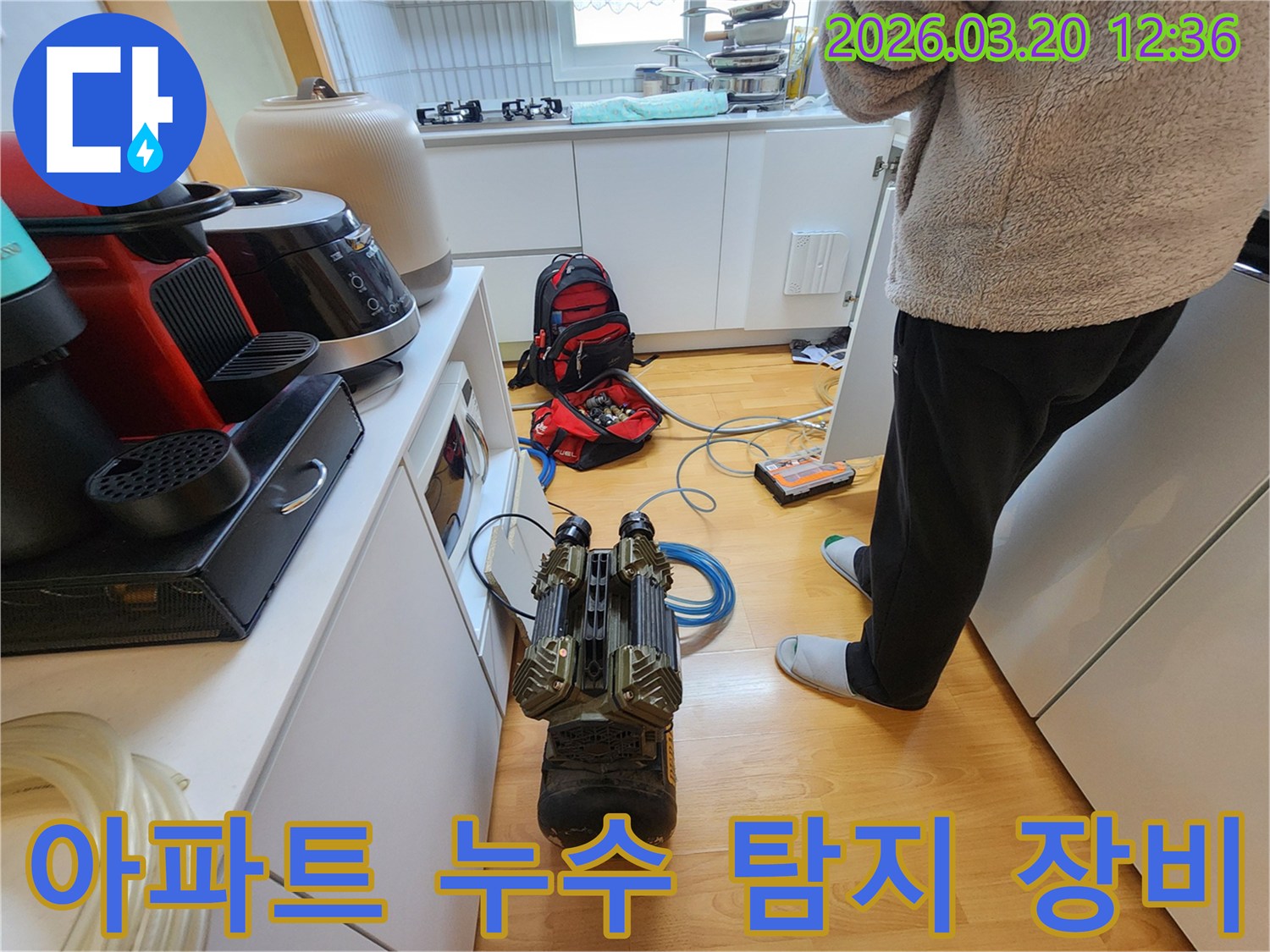 누수 엔지니어가-아파트 주방 누수 탐지를 위해-전문 장비를-현장에 설치하는 모습