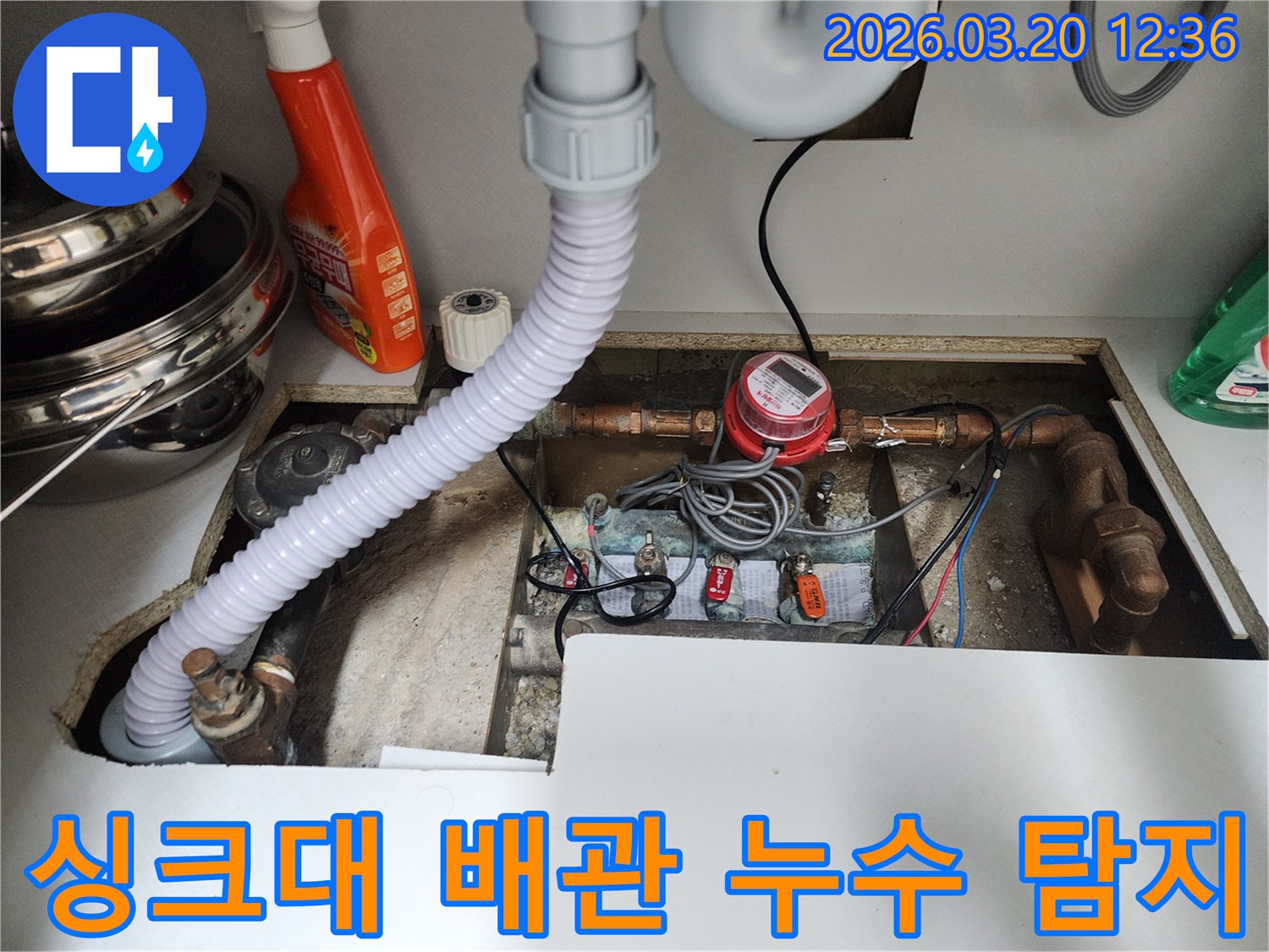 싱크대 아래-복잡한-배관과-계량기를-정밀하게-살펴보며-누수-지점을-탐지하는-모습입니다