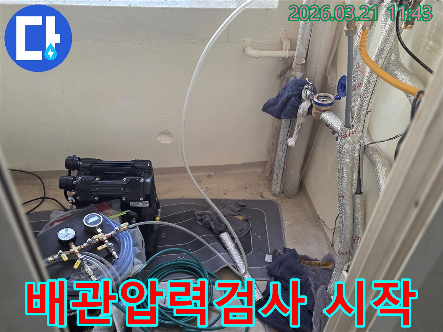 누수 엔지니어가-배관 압력 검사를 위해-전문 장비를 세팅하고 있습니다.