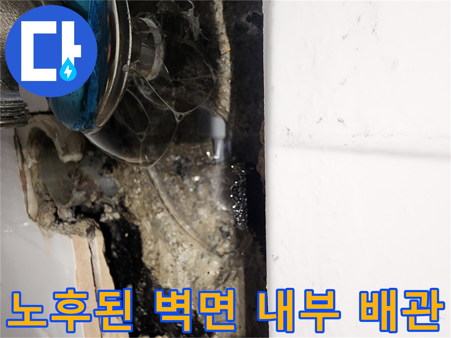 누수 확인을 위한 벽면 굴착 - 습기를 머금은 채 드러난 노후 배관과 주변 자재