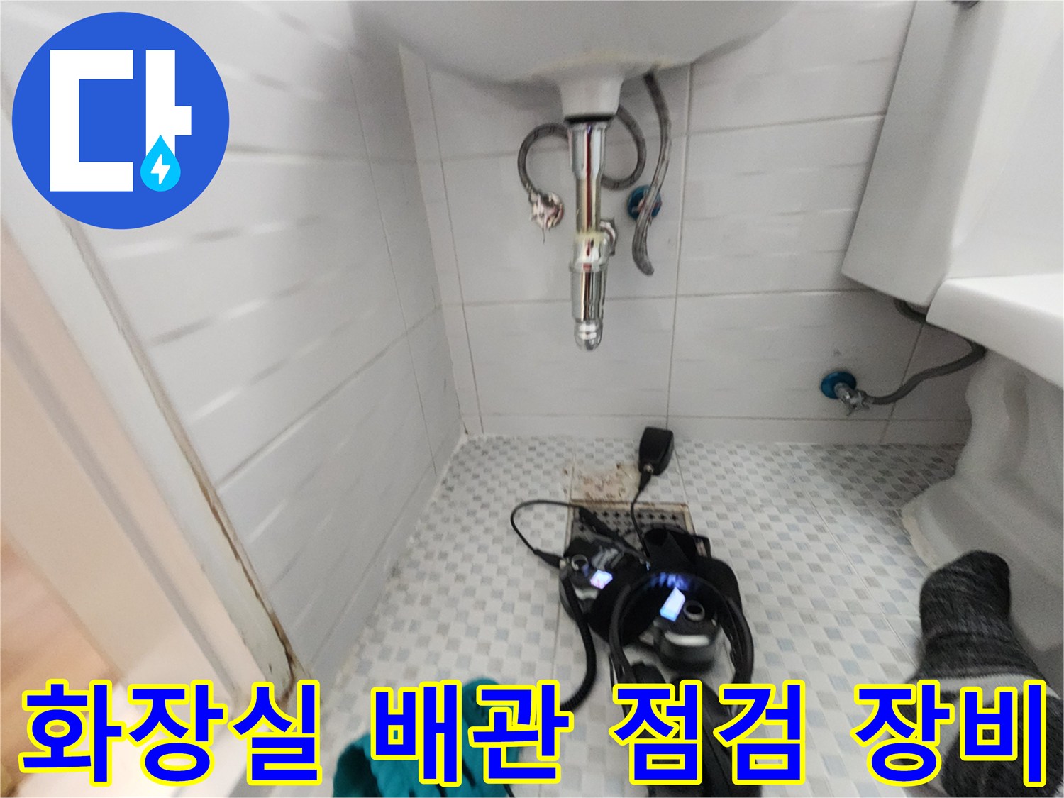 세면대 아래 설치된 디지털 압력계와 누수 탐지용 헤드셋 사진입니다.