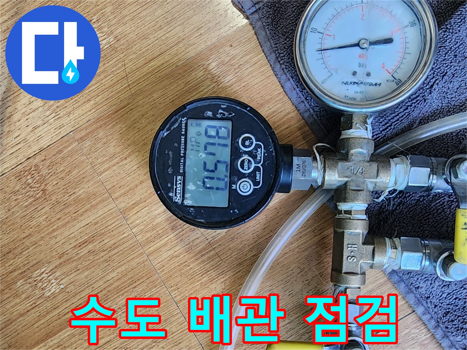 수도 배관 연결 부위에 압력계를 설치하여 수치를 모니터링하는 장면
