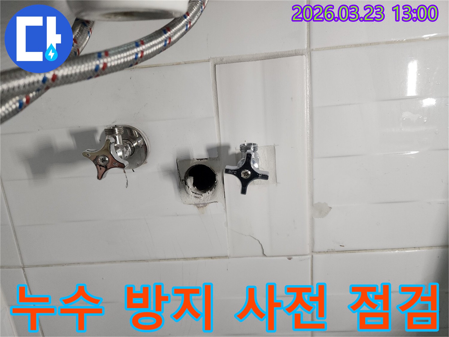 하얀색 타일 벽면의-수도 배관 연결 부위에서-누수가 확인되어-타일을 제거하고-배관을 점검하는-누수 현장입니다.