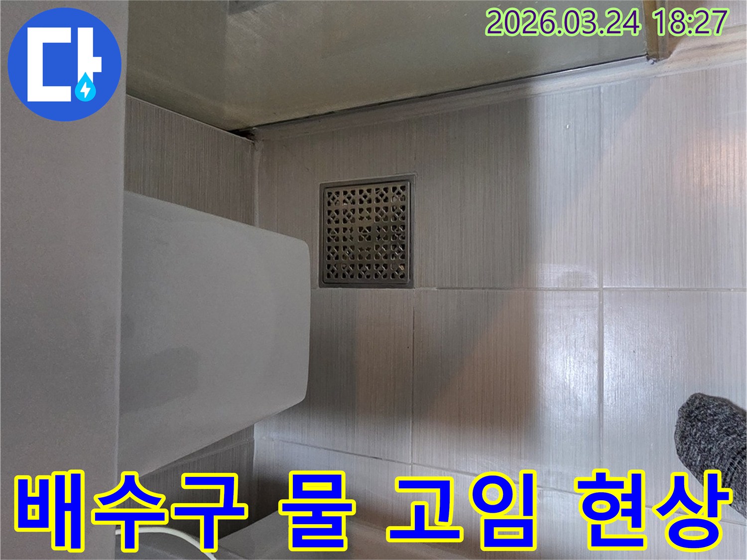 동두천시 주택 화장실에서-배수구 주변의 물 고임 현상을 관찰하며-누수 원인을 파악하는-전문가의 현장 점검 사진입니다.
