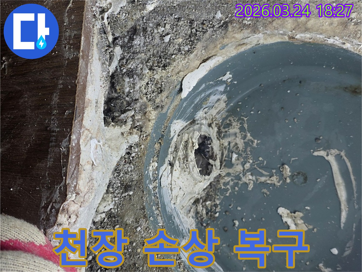 배수구 주변 물샘으로 인한 천장 손상을 복구하는 공사 현장 사진입니다.