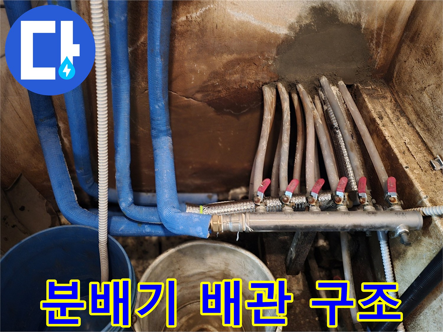 파란색 보온재와 금속 분배기가 연결된 복잡한 배관 상태