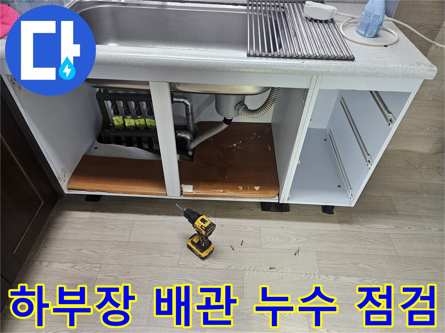 싱크대 하단 내부-분배기와 젖은 바닥면 상세 사진