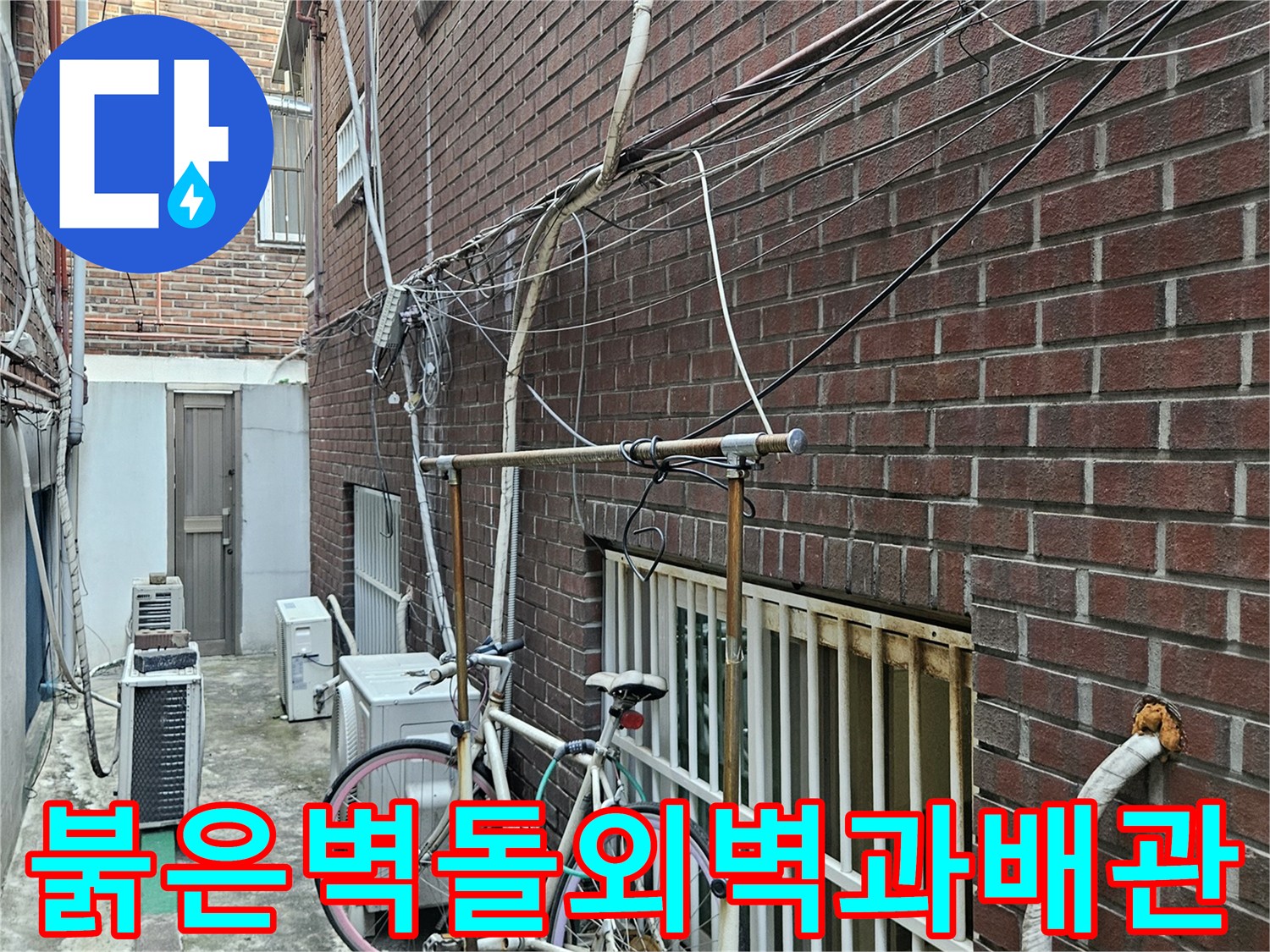 붉은색-벽돌로-마감된-건물-외벽에-연결된-외부-배관-상태