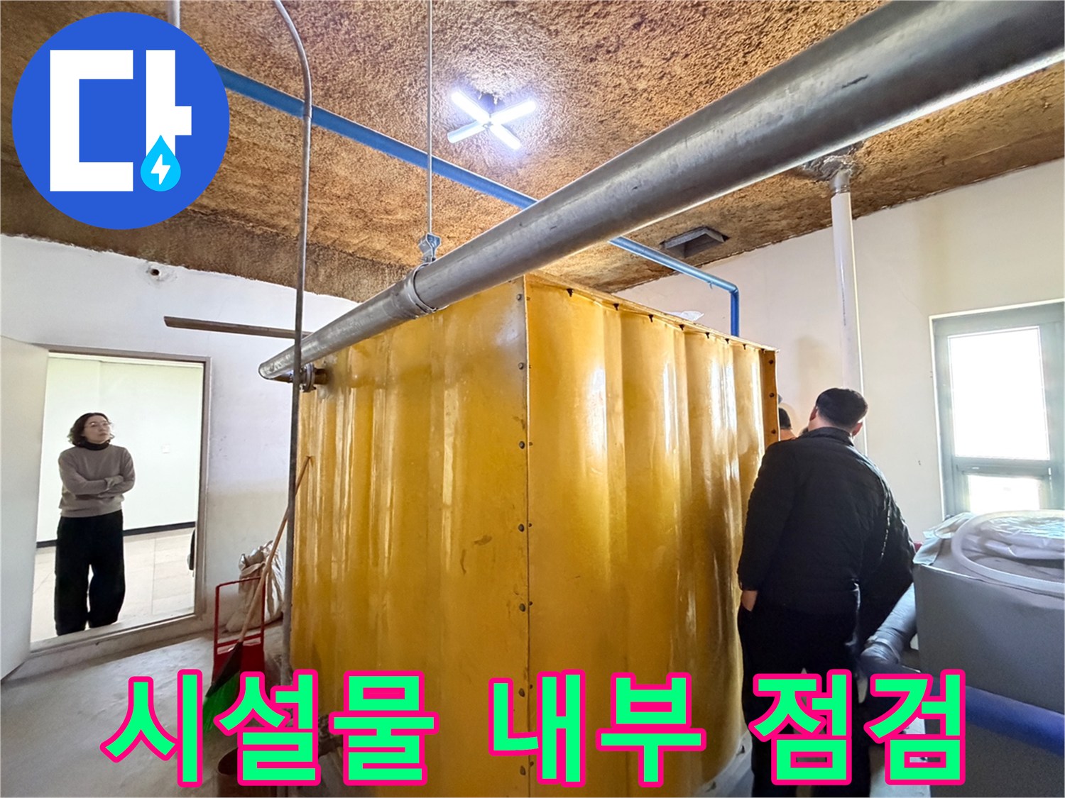 대형 노란색 탱크와 천장에 설치된 금속 관로의 모습입니다.