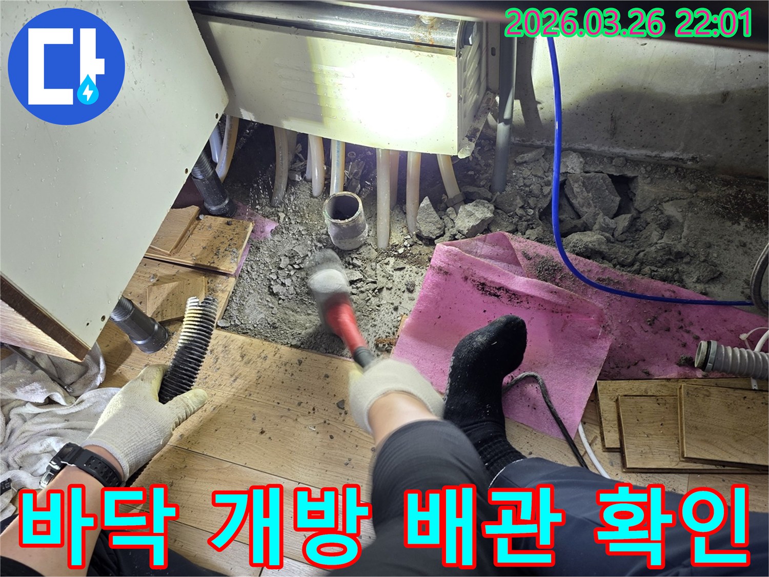 누수 공사의 첫 단계로-바닥재를 제거하고-배관 상태를 점검하는 전문가의 손길