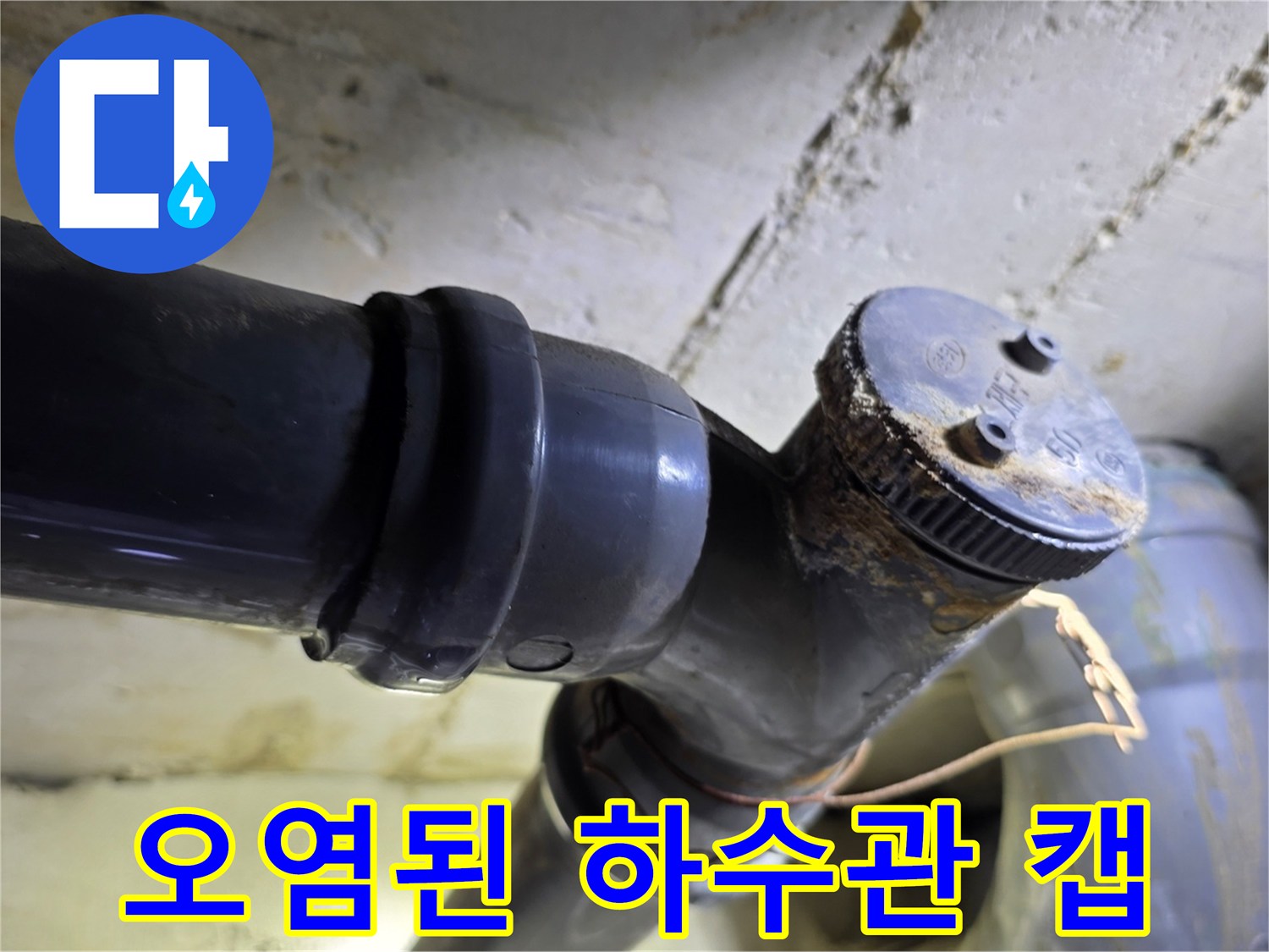 하수 배관의-부식된 캡과 연결 부위의 오염 상태를 보여주는 사진입니다.