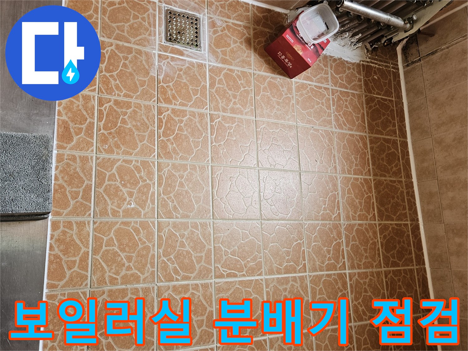 분배기 하단 연결 부위와 주변 타일의 물샘 흔적을 보여주는 사진