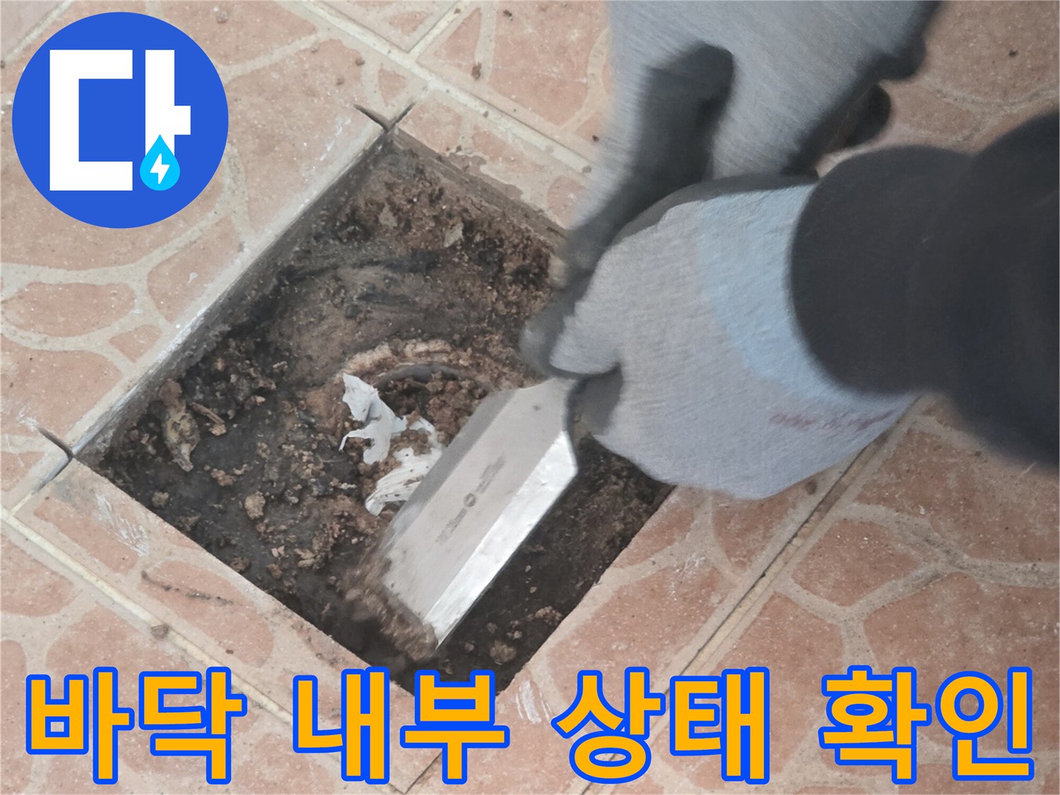 타일 아래 젖은 토양과 배관 주변을 조사하는 모습입니다.