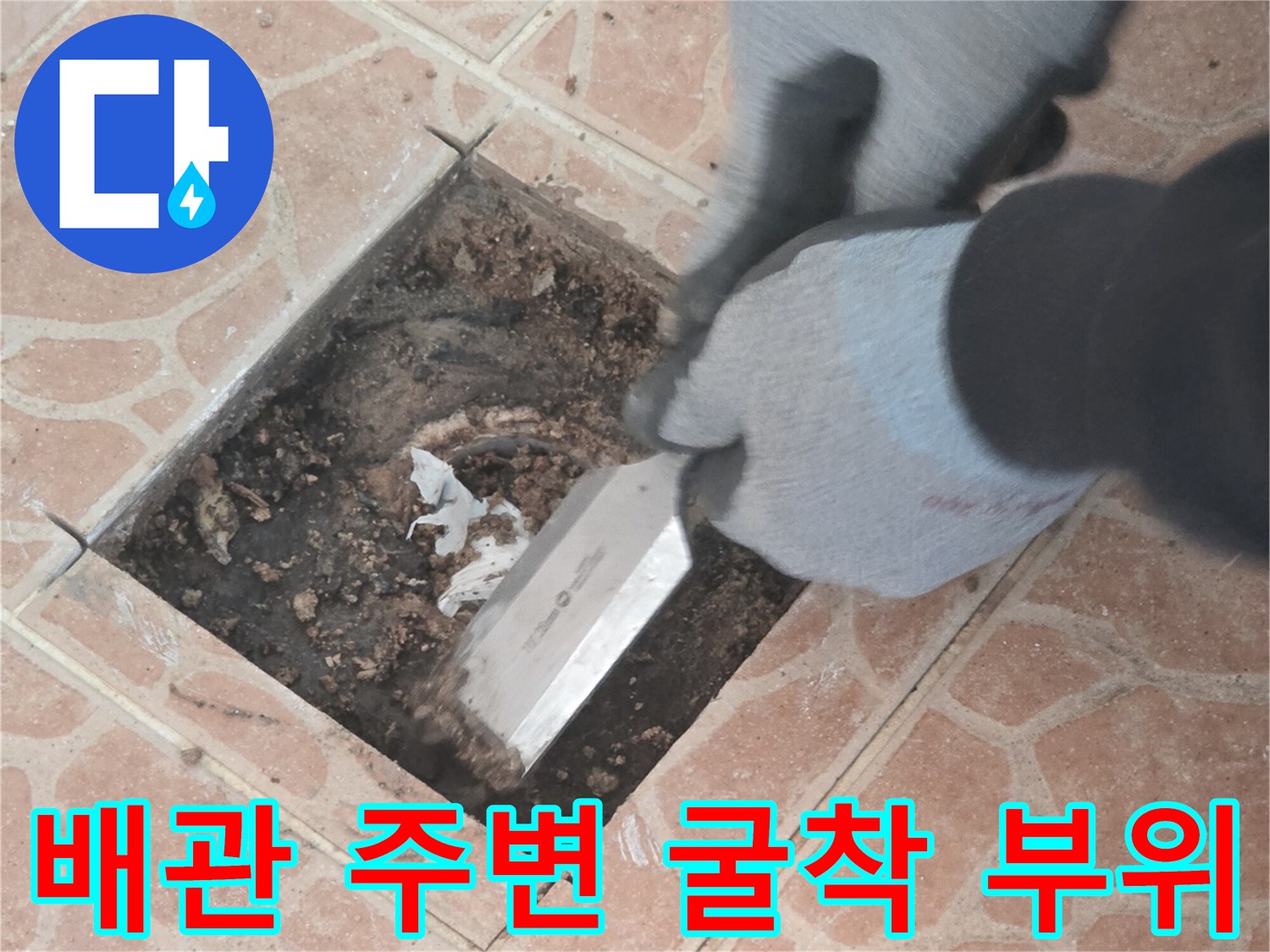 헤라를 사용하여 타일 아래 흙을 정리하는 작업자 손