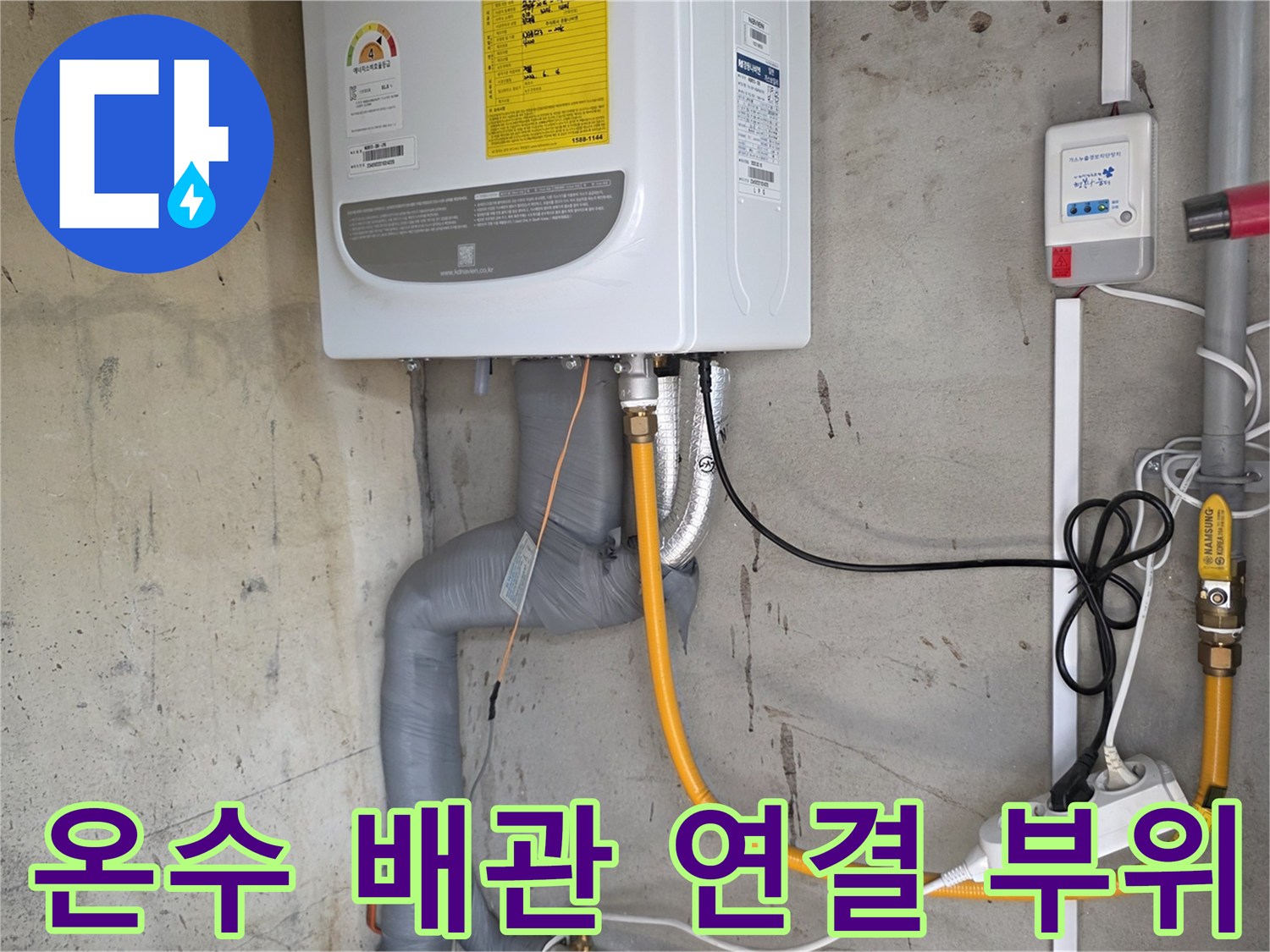 보일러 하부-노란색 배관과 전원 콘센트의 모습