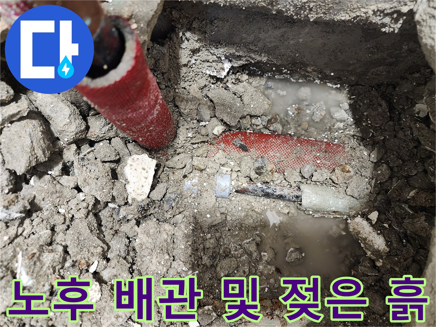 붉은 보온재가 보이는 누수 배관과 젖은 토사
