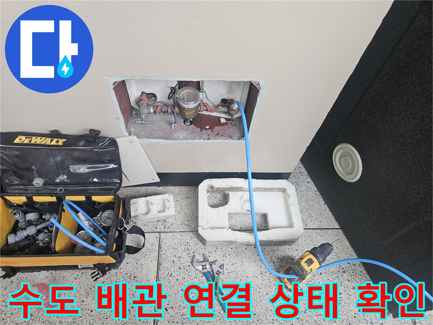 벽면 굴착 부위에 노출된 수도 배관과 측정용 호스 연결
