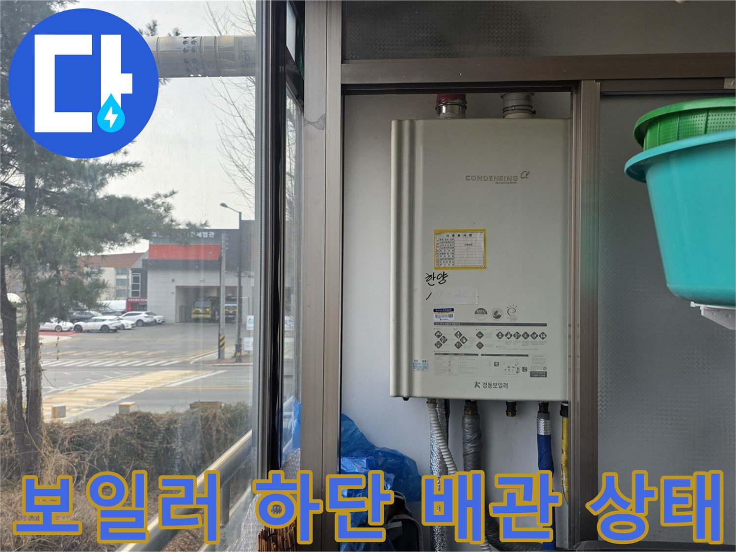 보일러 본체 아래에 연결된 급수 및 온수 배관의 모습입니다.