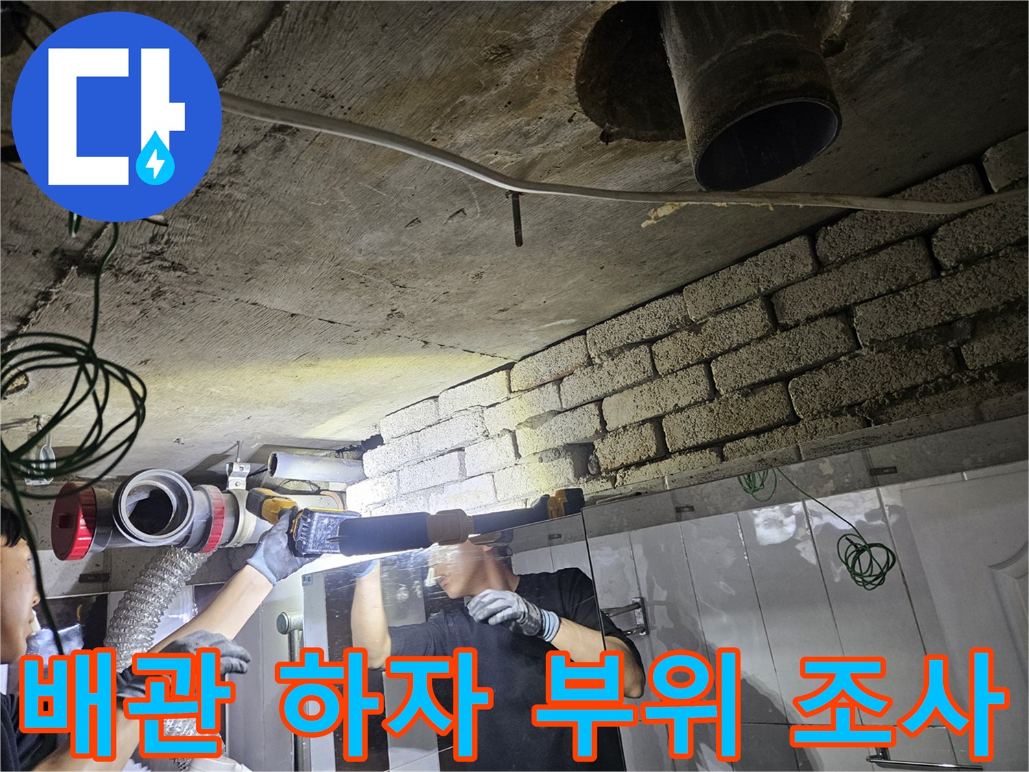 손전등을 비추어-천장 내부 배관의 누수 흔적을 추적하는 모습