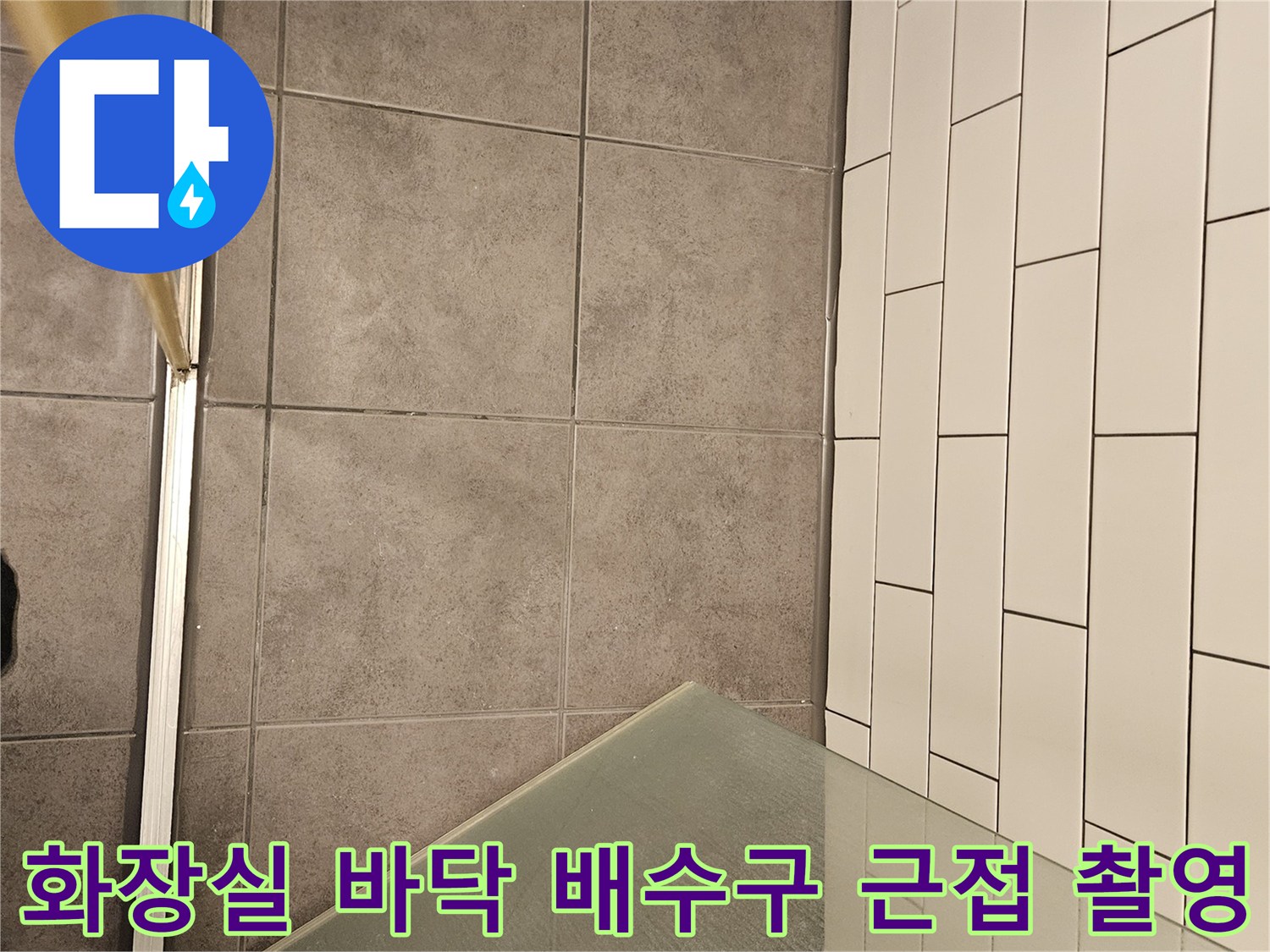 회색 타일 바닥에 설치된 금속 소재의 하수구 유가