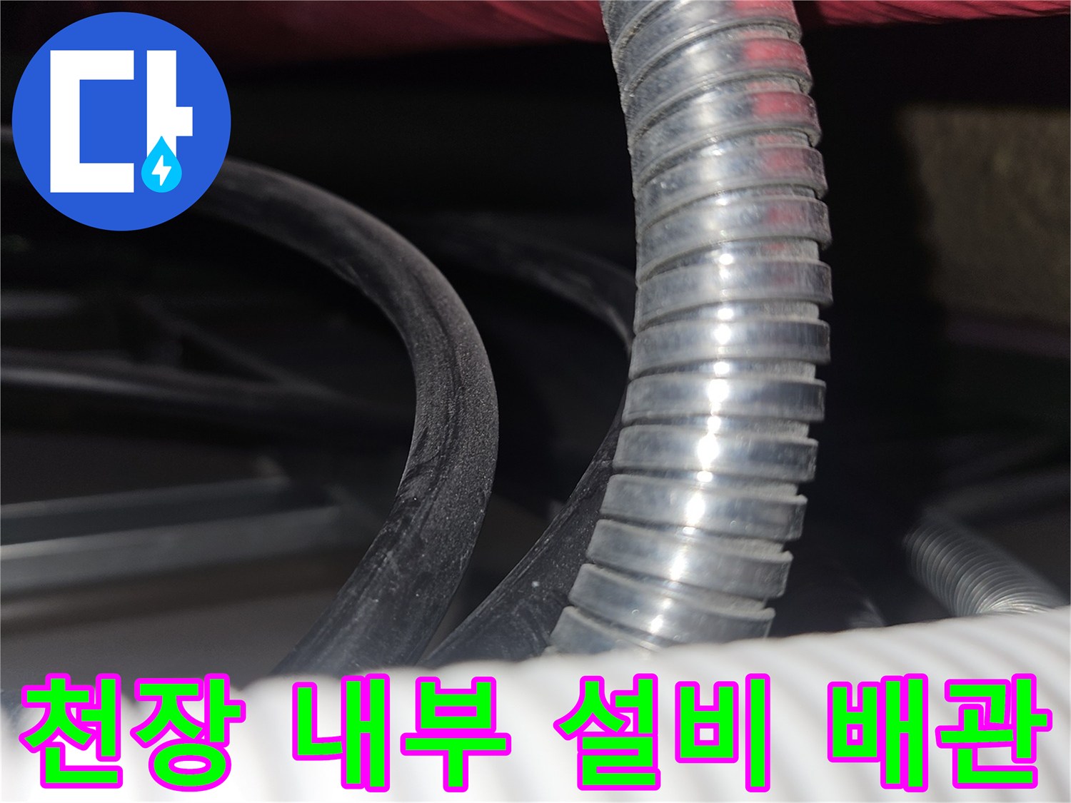 하얀색 주름관과 빨간색 보선재 배관이 보이는 천장 내부