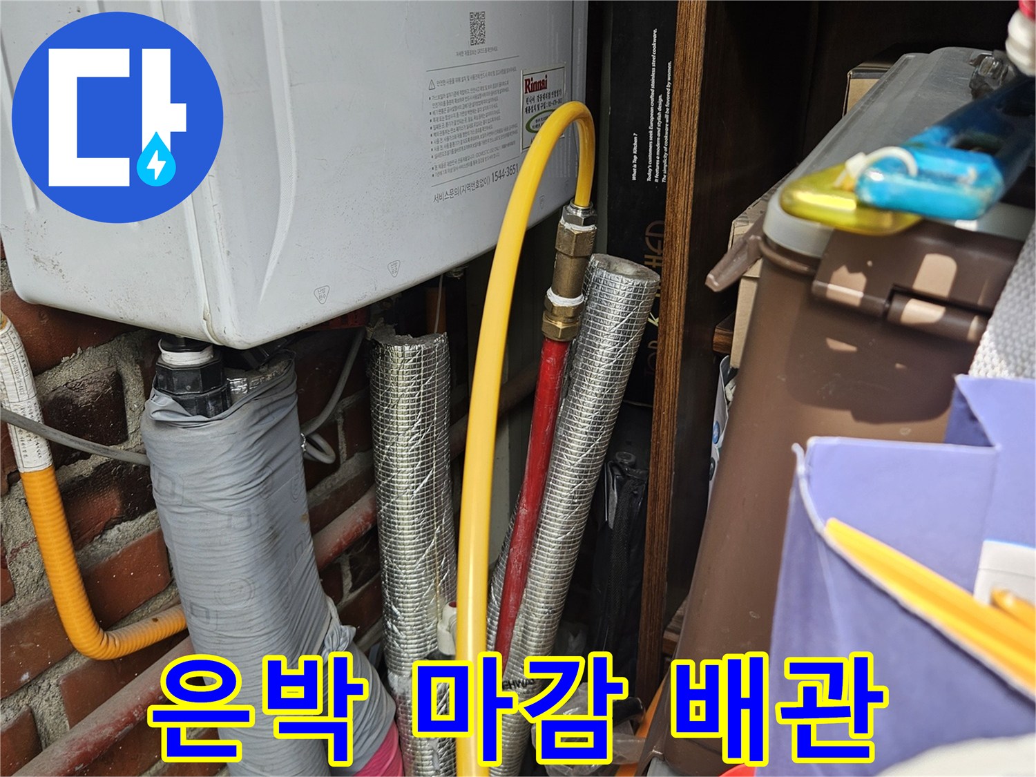 보일러 하단에 배치된 노란색 호스와 은색 보온재 배관