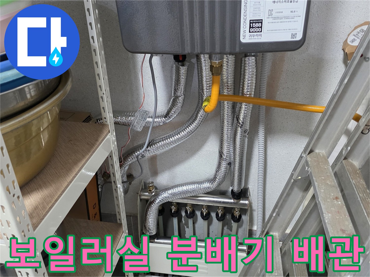 보일러 하단에 연결된 은색 주름관과 분배기 모습입니다.