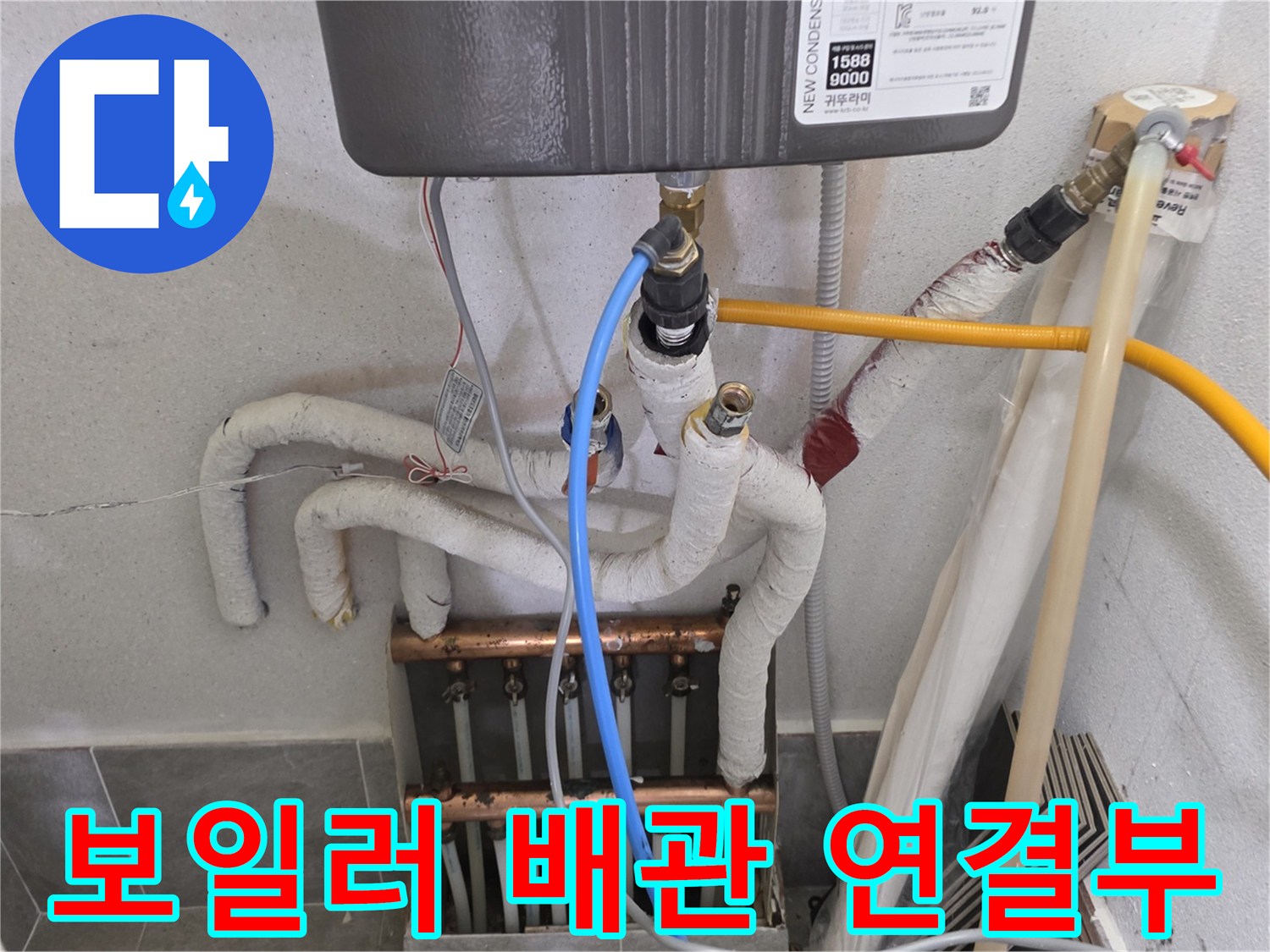 보일러실 하단에 복잡하게 얽힌 배관과 분배기 모습