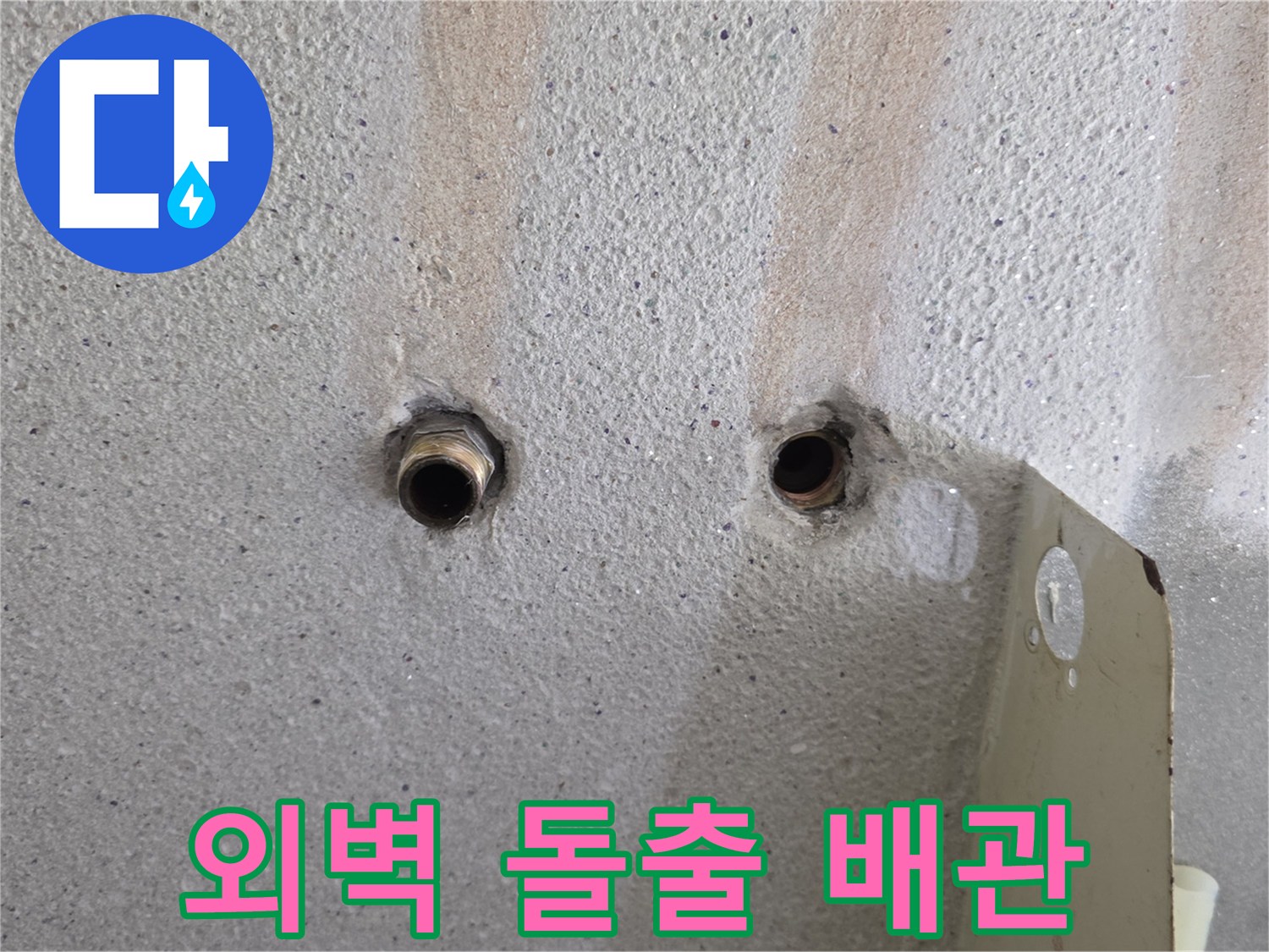 콘크리트 벽면에서 외부로 튀어나온 배관 연결 부위입니다.