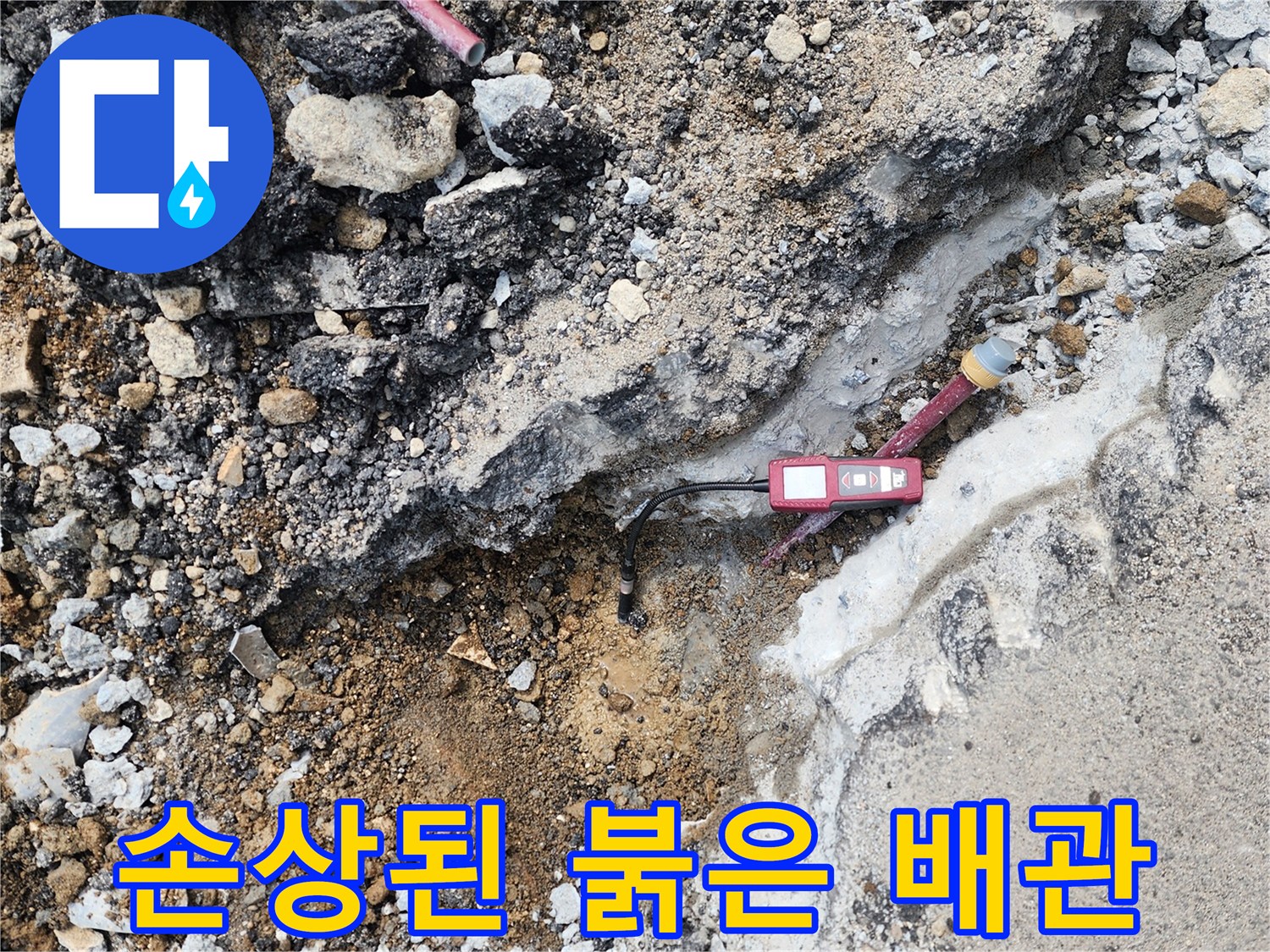 흙 속에 드러난 파손된 붉은색 수도 배관