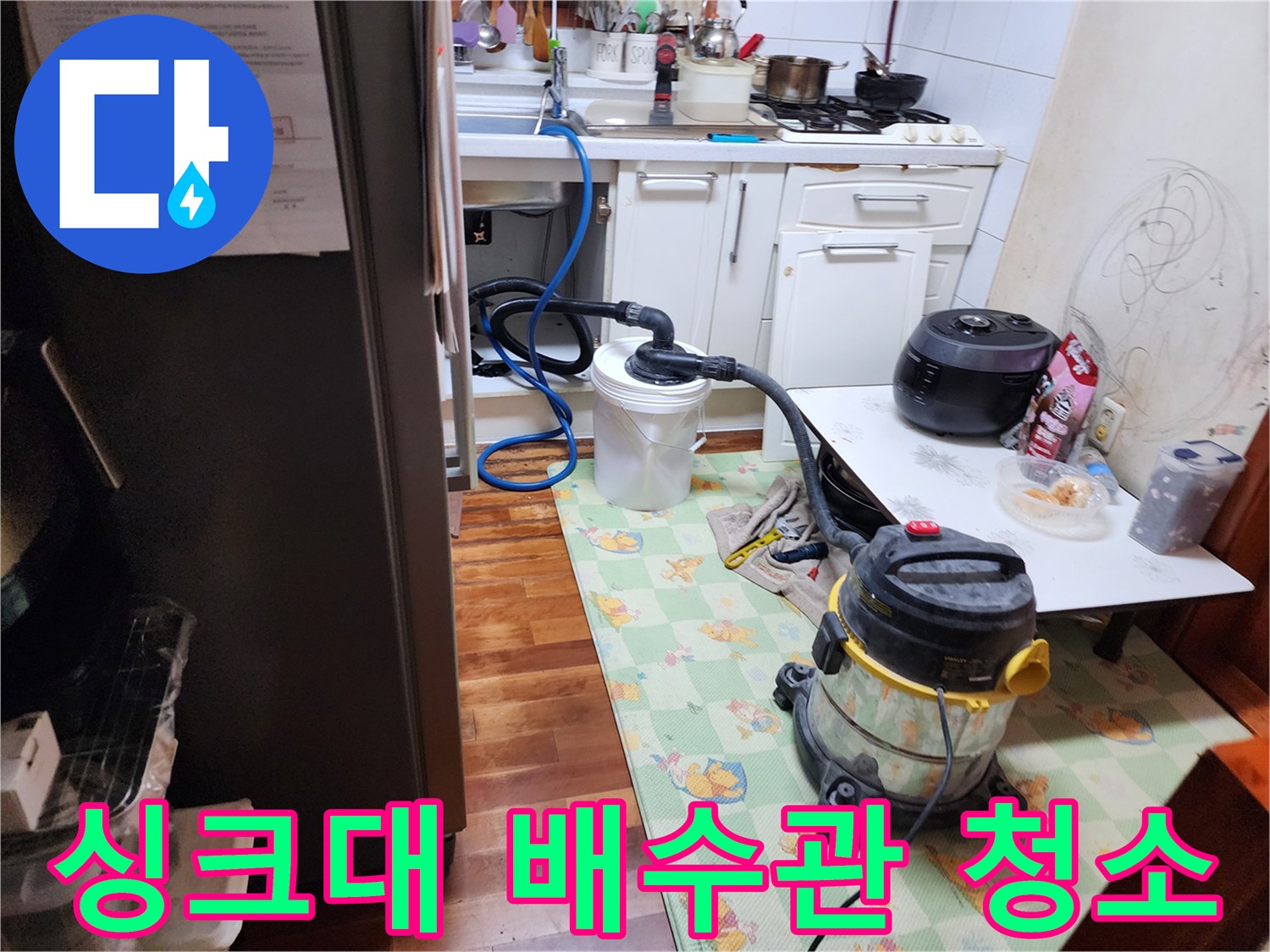 석션기를 사용하여 싱크대 하수구의 오물을 흡입하는 장면