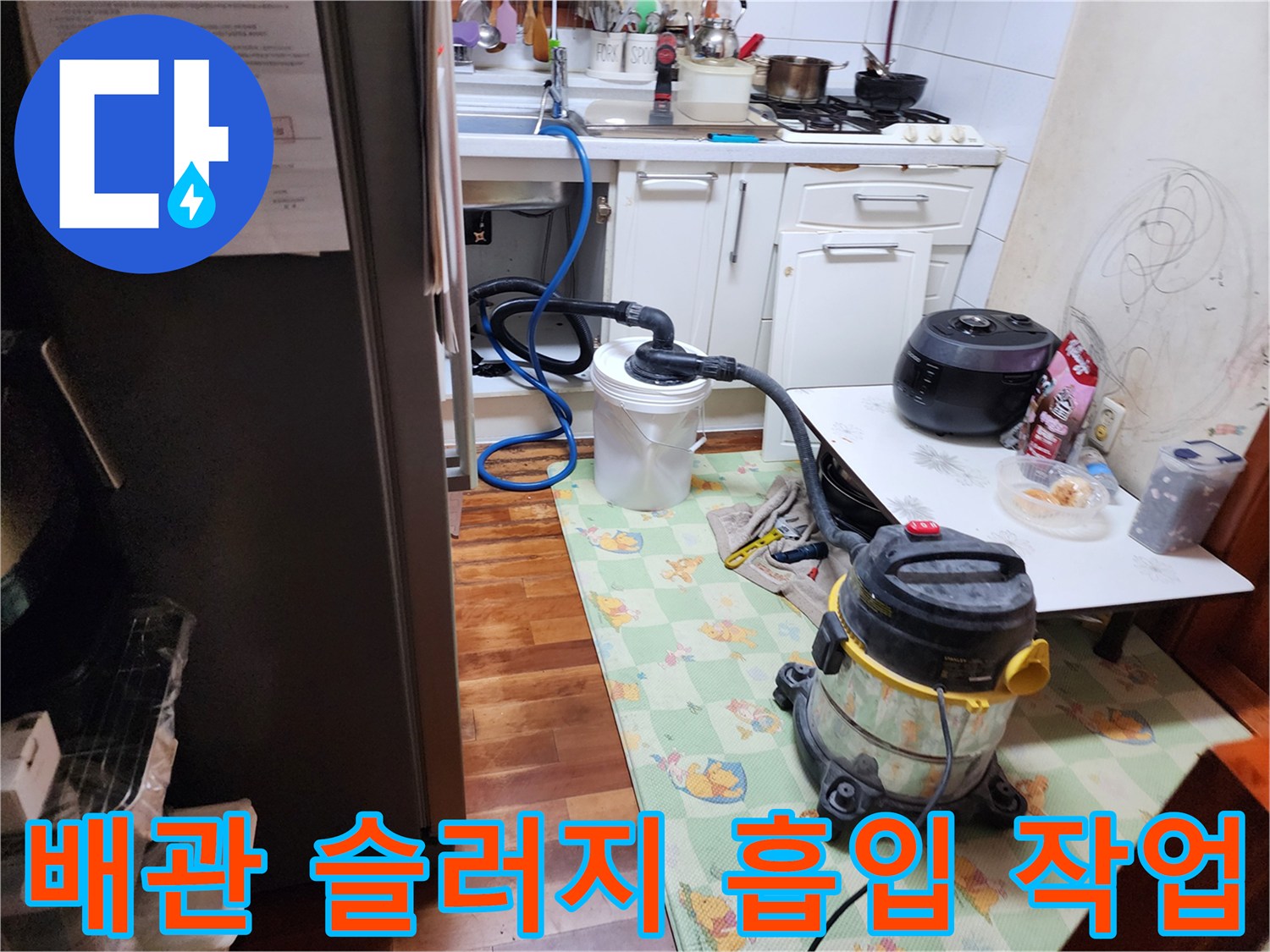 주방 하수관의 막힘을 해결하기 위해 가동 중인 석션 장비와 호스 연결