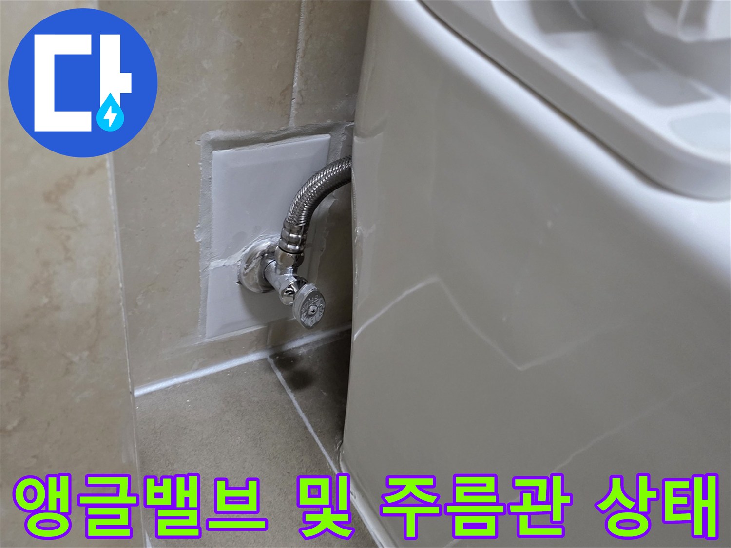 벽면 타일에 설치된 앵글밸브와 은색 유연 배관