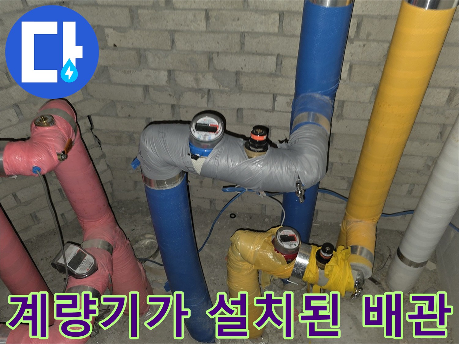 수도 계량기와 함께 연결된 다채로운 색상의 보온 배관 시설물 사진
