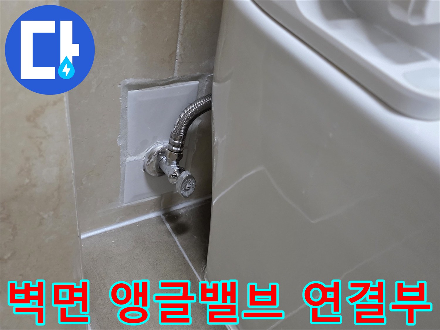 타일 벽면에 설치된 수도 밸브와 은색 주름관 상세