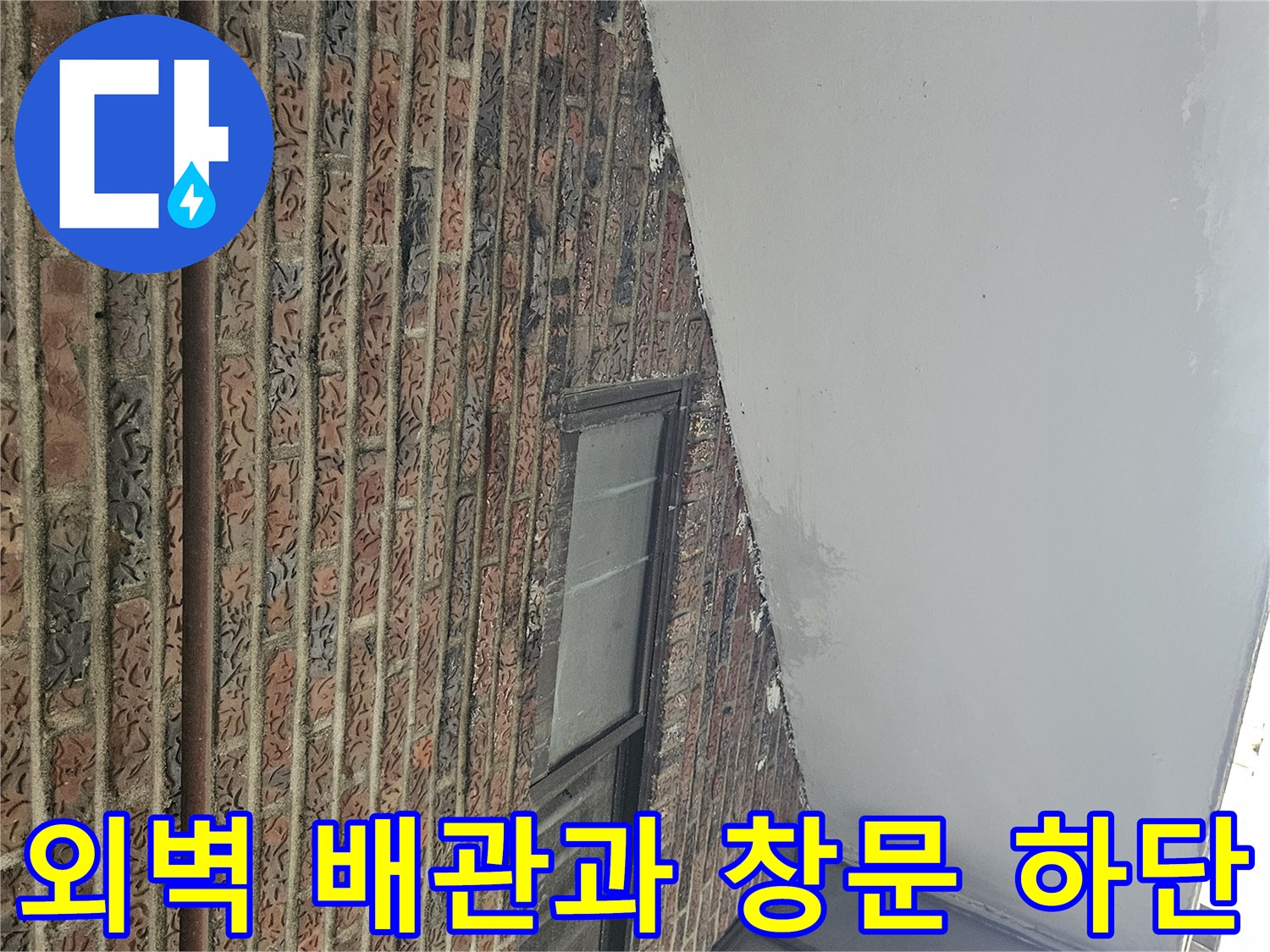 붉은 벽돌 외벽에 설치된 금속 관과 창문 프레임