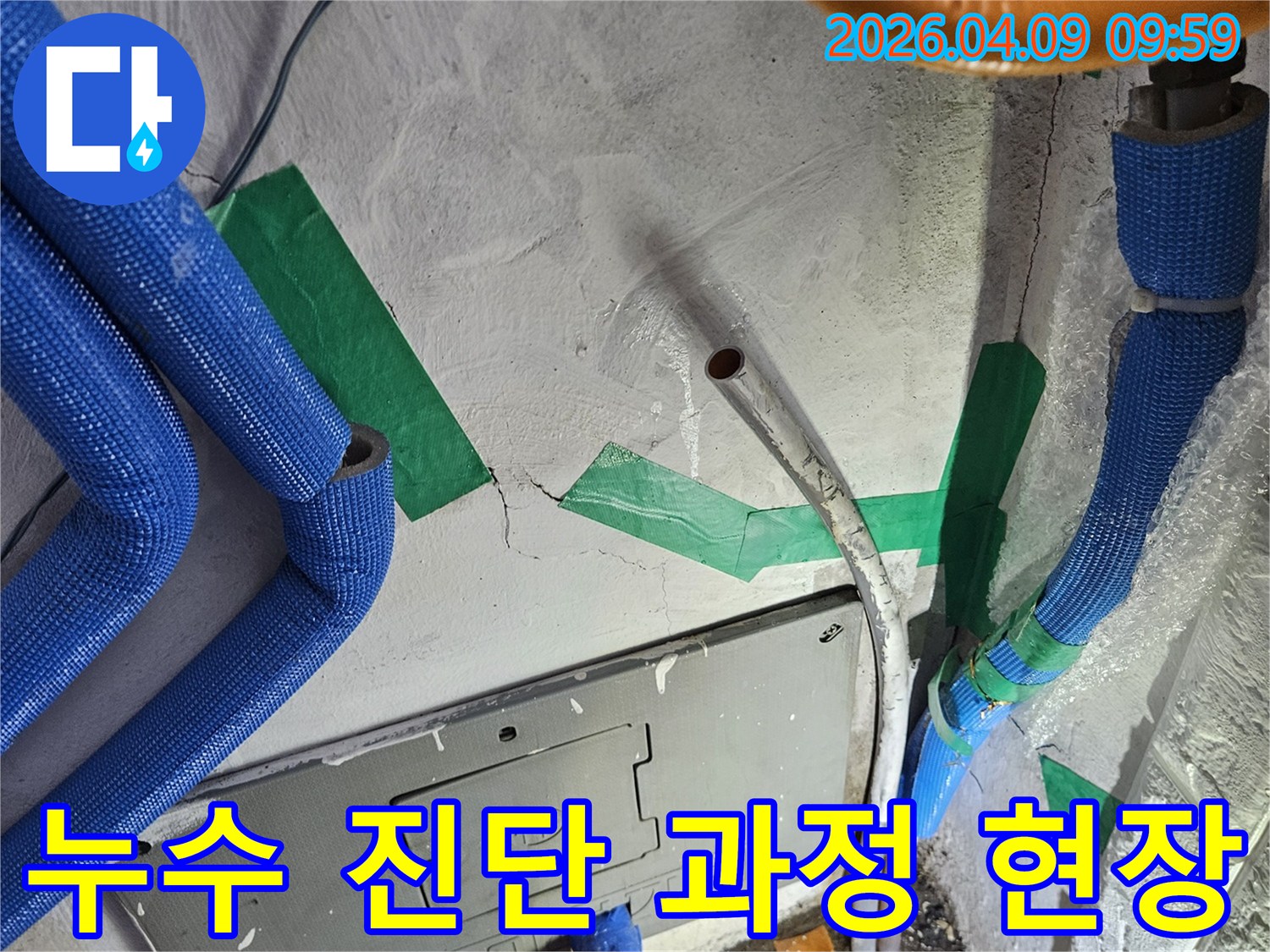 벽면 콘크리트의-균열과-노출된 배관들-그리고 전기함 주변을-전문가가-정밀하게 진단하는-누수 진단 과정의-한 장면